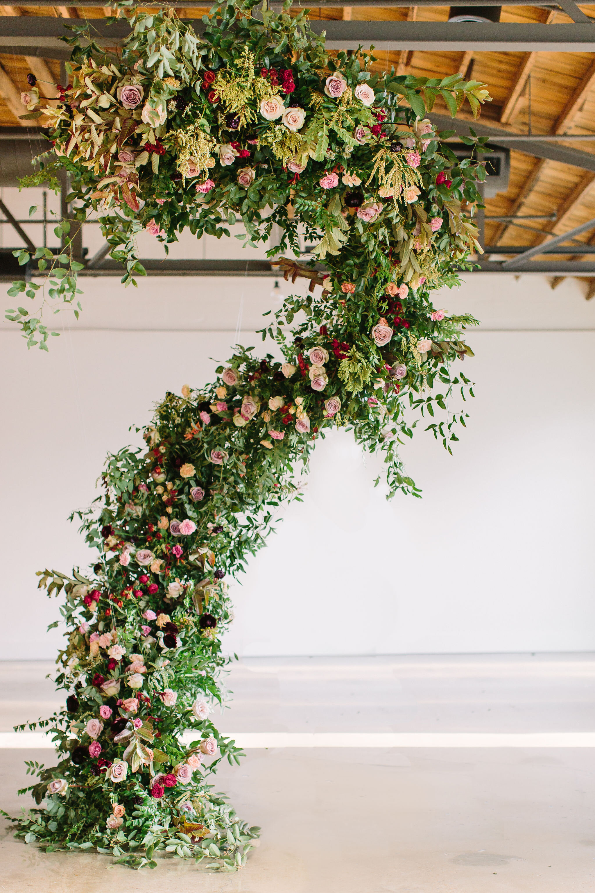 An intimate installation intensive at The Saint Elle in Nashville. Students learned how to create and build 3 different kinds of installations. This spiraling install is filled with rust, plum, and terracotta flowers including toffee and lavender ro…
