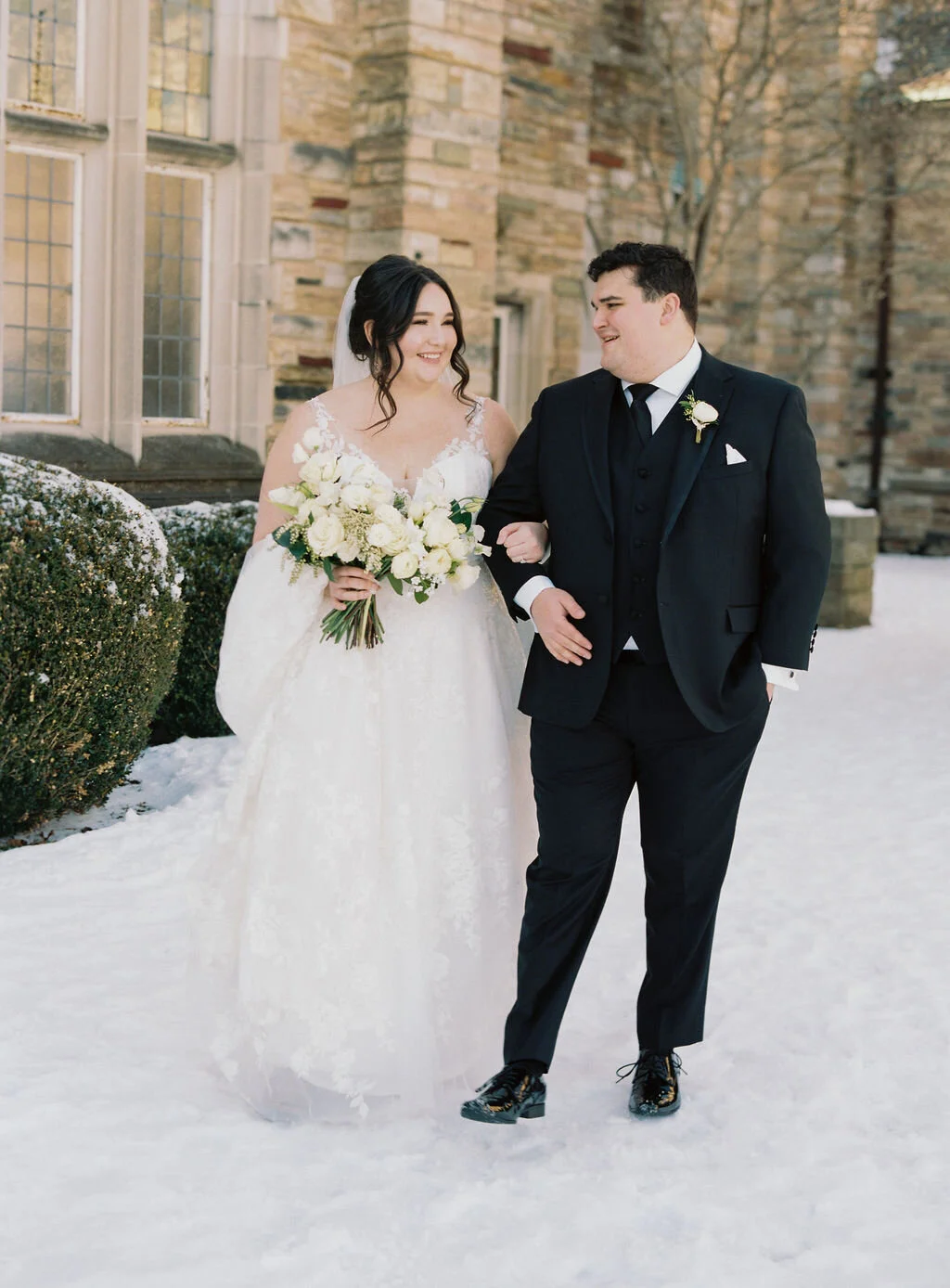 This wintery bridal bouquet is filled with white ice roses, fluffy ranunculus, draping pieris, majolica spray roses, white sweet pea, ivory lisianthus, and patience garden rose. Designed by florist Rosemary & Finch in Nashville, TN.