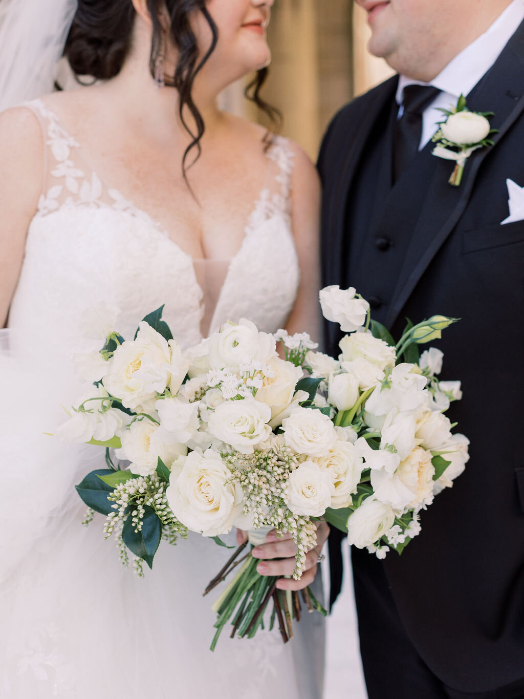 This wintery bridal bouquet is filled with white ice roses, fluffy ranunculus, draping pieris, majolica spray roses, white sweet pea, ivory lisianthus, and patience garden rose. Designed by florist Rosemary & Finch in Nashville, TN.