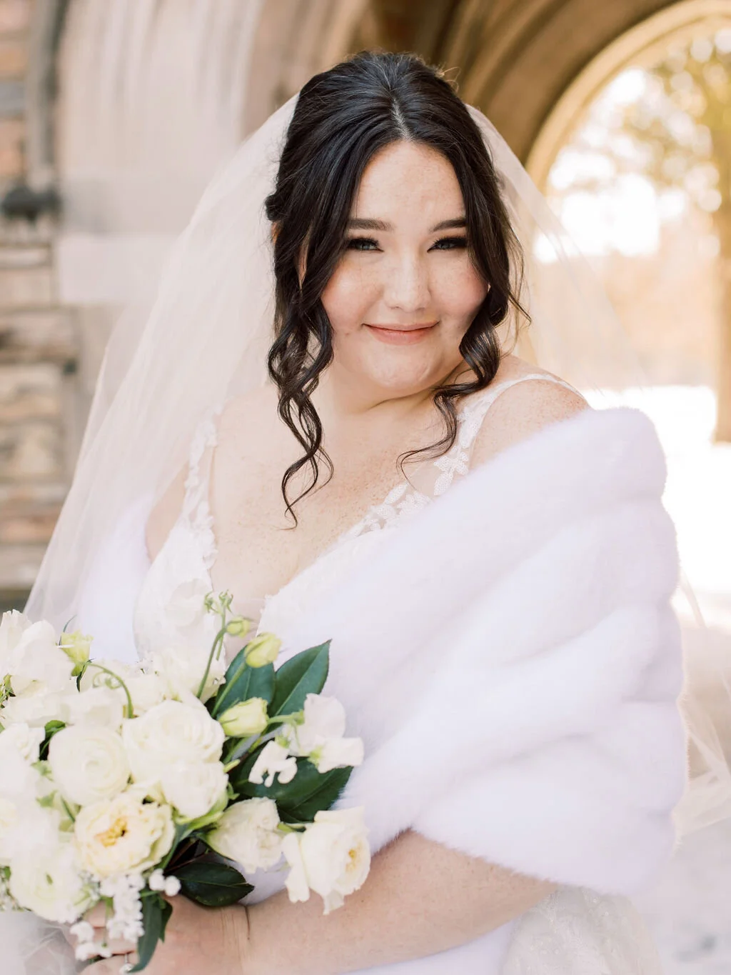 This wintery bridal bouquet is filled with white ice roses, fluffy ranunculus, draping pieris, majolica spray roses, white sweet pea, ivory lisianthus, and patience garden rose. Designed by florist Rosemary & Finch in Nashville, TN.