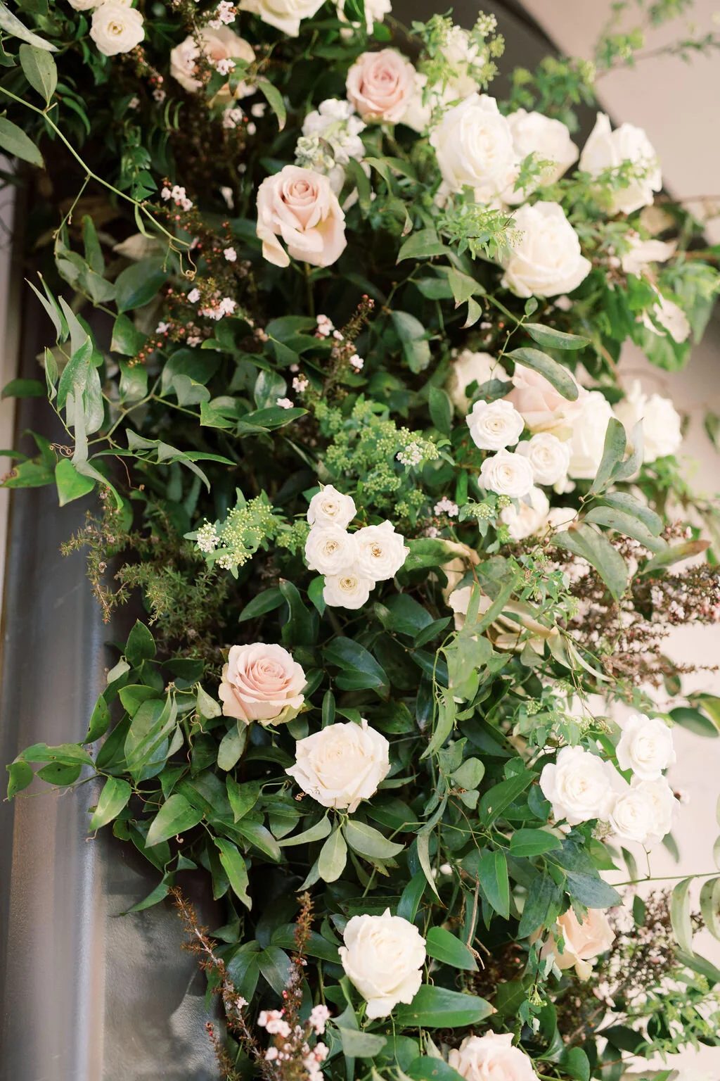 A growing installation of blush and ivory garden roses, white ranunculus, creamy spray roses, delicate eriostemon and lush greenery separated the reception area from the lounge area at the Cordelle. Designed by florist Rosemary & Finch in Nashville,…