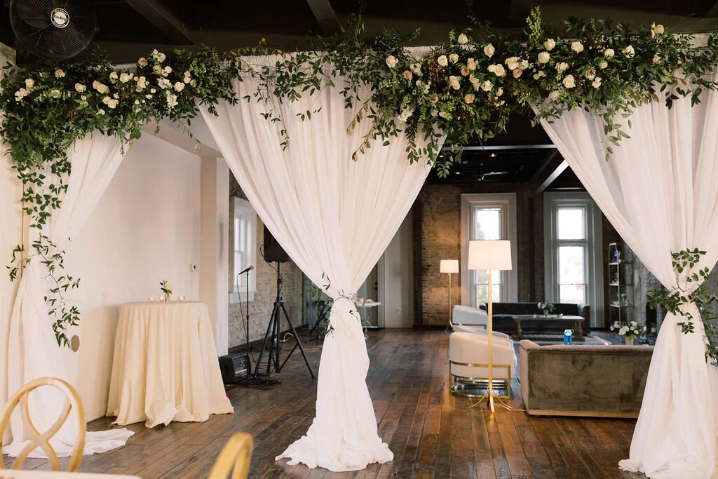 A growing installation of blush and ivory garden roses, white ranunculus, creamy spray roses, delicate eriostemon and lush greenery separated the reception area from the lounge area at the Cordelle. Designed by florist Rosemary & Finch in Nashville,…