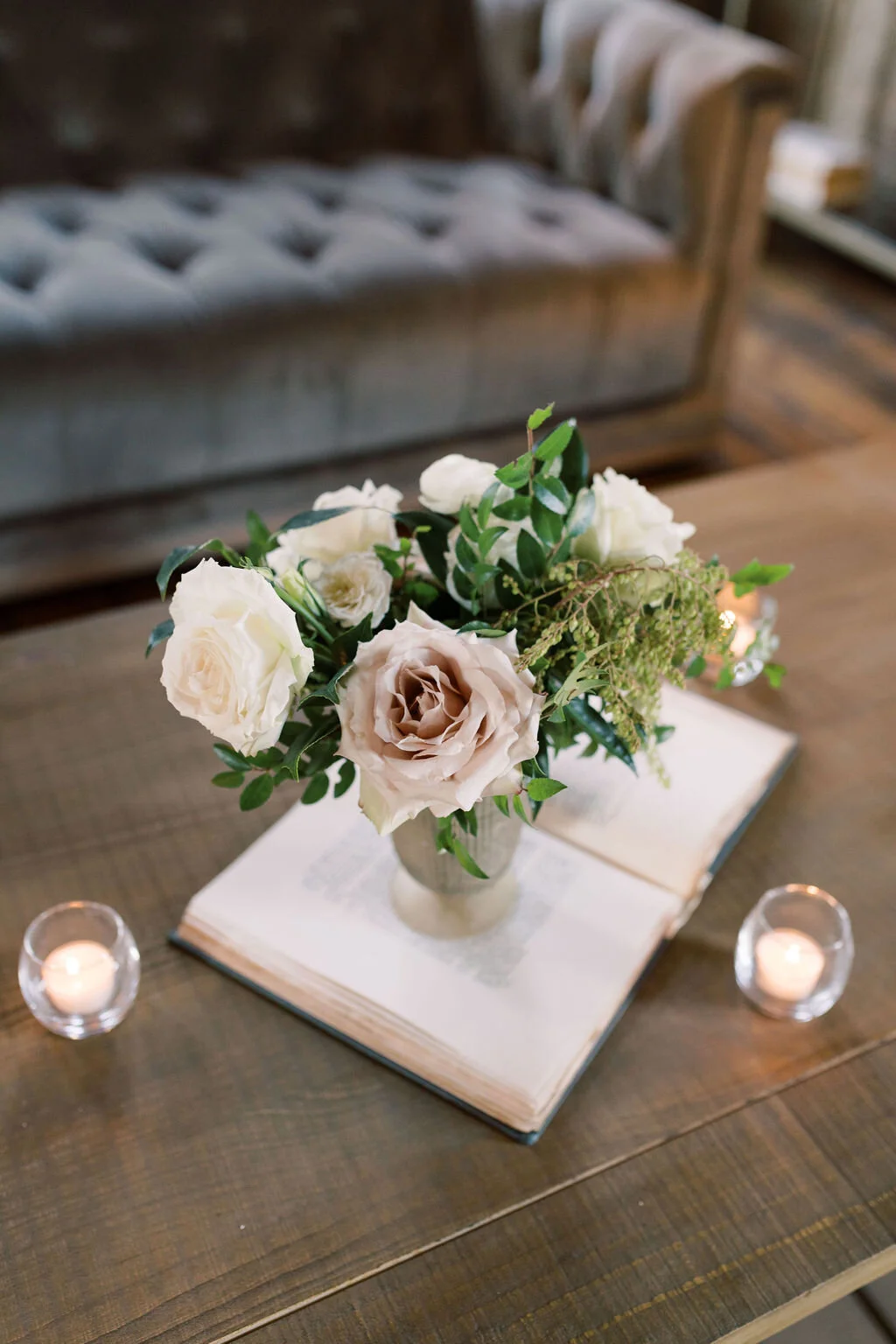 This twinkling reception is filled with taupe tapers in collected brass candlesticks. Centerpieces filled with delicate blooms of quicksand roses, white ice roses, majolica spray roses, fluffy ranunculus, white stock, delicate sweet pea and natural …