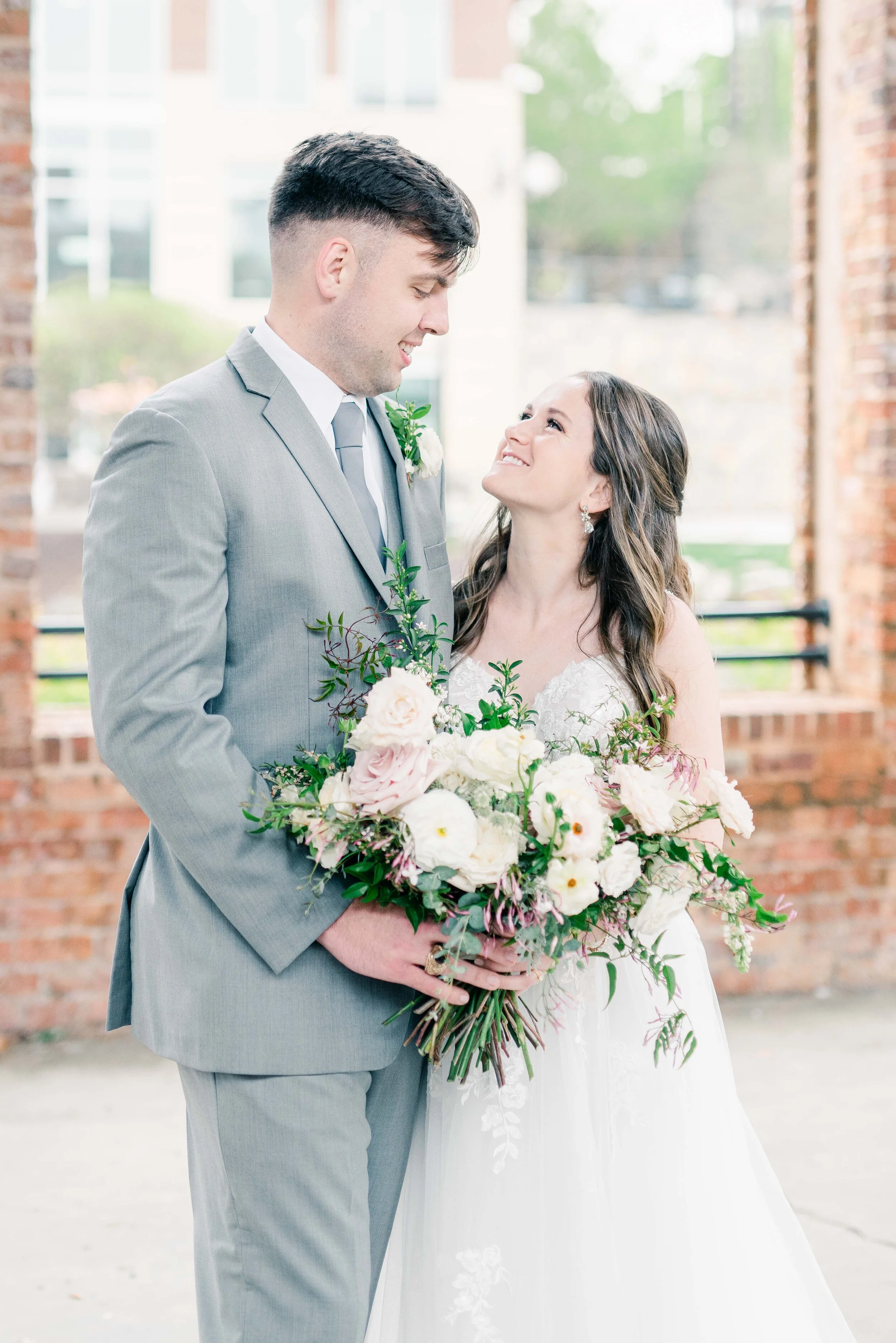 Champagne roses, cream garden roses, trailing jasmine, fluffy ranunculus, quicksand roses, majolica spray roses, and sage eucalyptus make up this gorgeous bridal bouquet. Designed by florist Rosemary & Finch in Nashville, TN.
