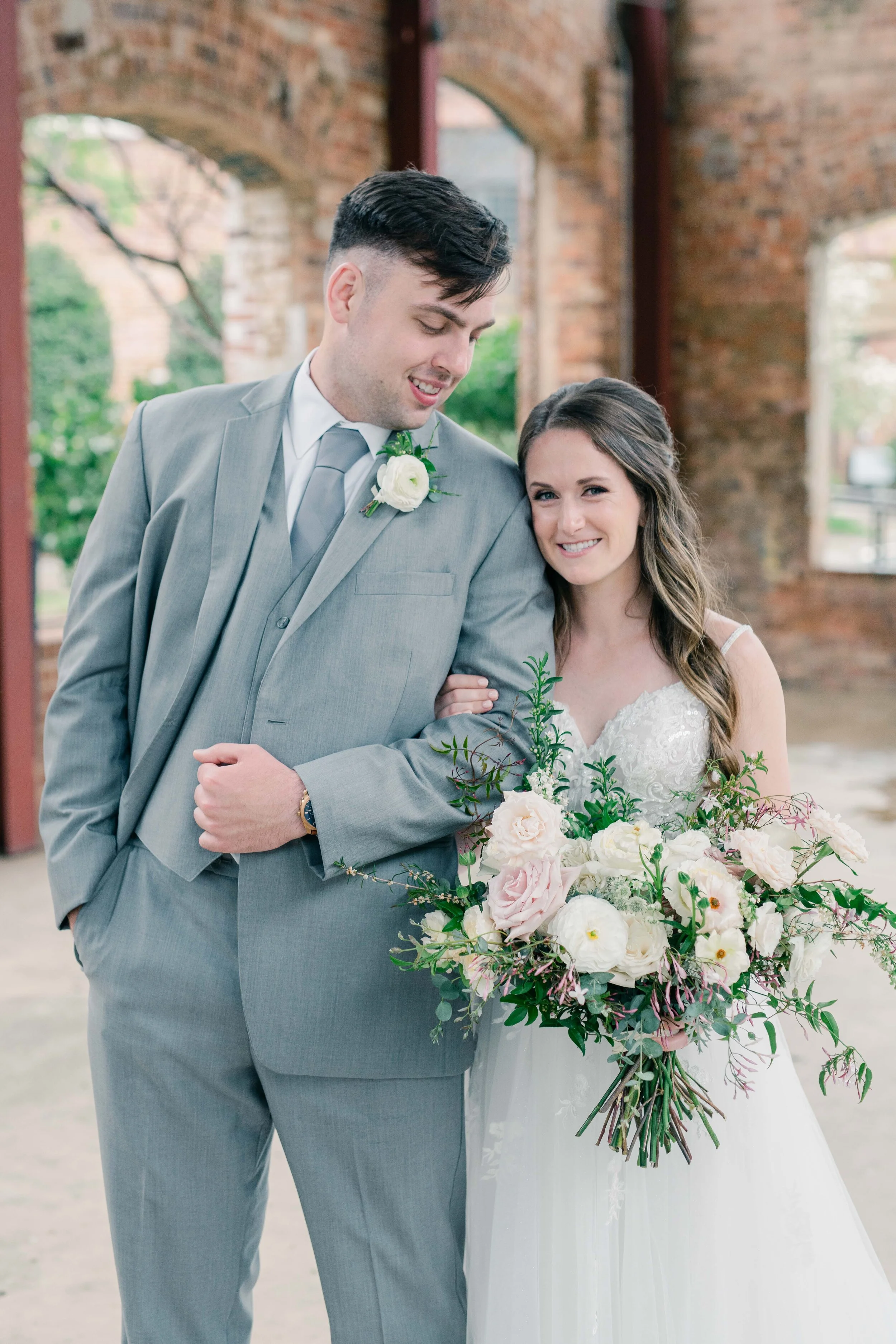 Champagne roses, cream garden roses, trailing jasmine, fluffy ranunculus, quicksand roses, majolica spray roses, and sage eucalyptus make up this gorgeous bridal bouquet. Designed by florist Rosemary & Finch in Nashville, TN.