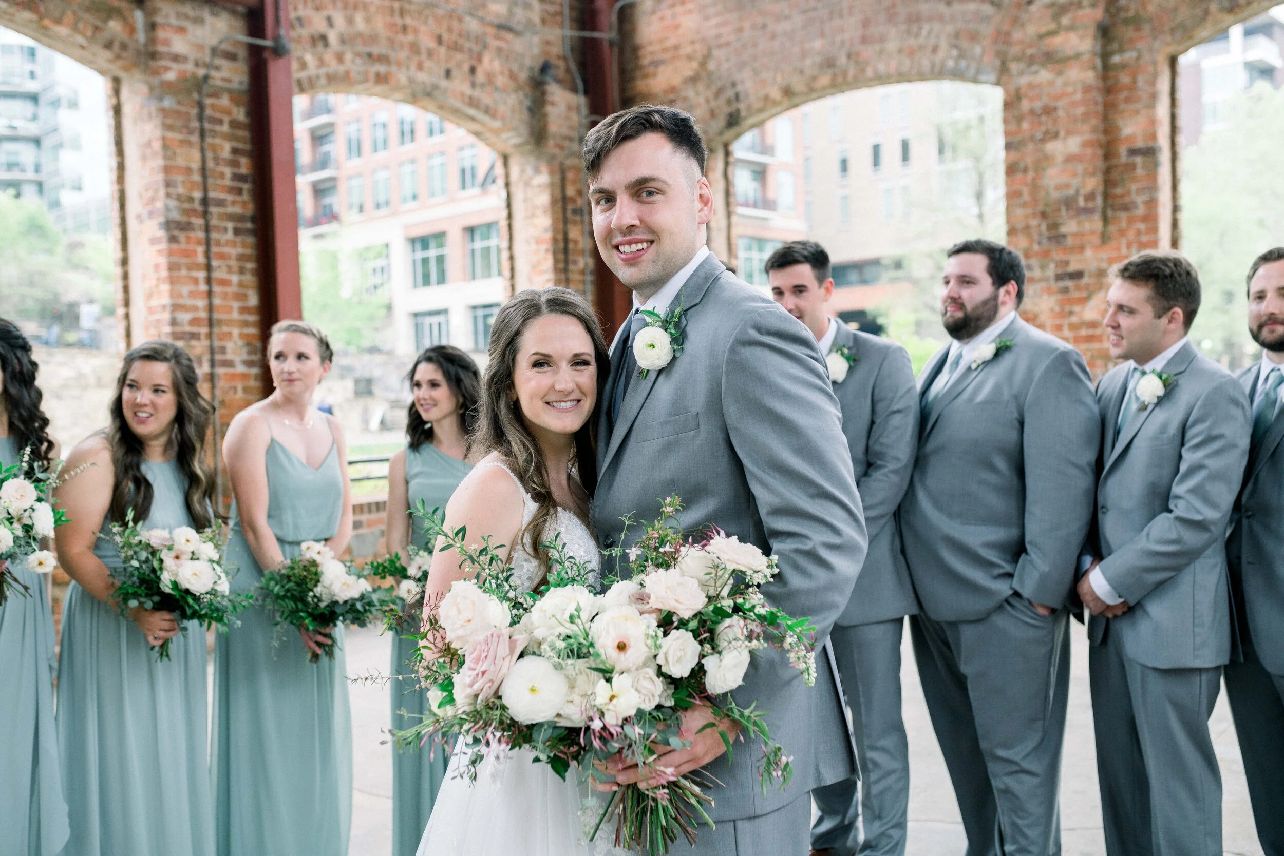 Champagne roses, cream garden roses, trailing jasmine, fluffy ranunculus, quicksand roses, majolica spray roses, and sage eucalyptus make up this gorgeous bridal bouquet. Designed by florist Rosemary & Finch in Nashville, TN.