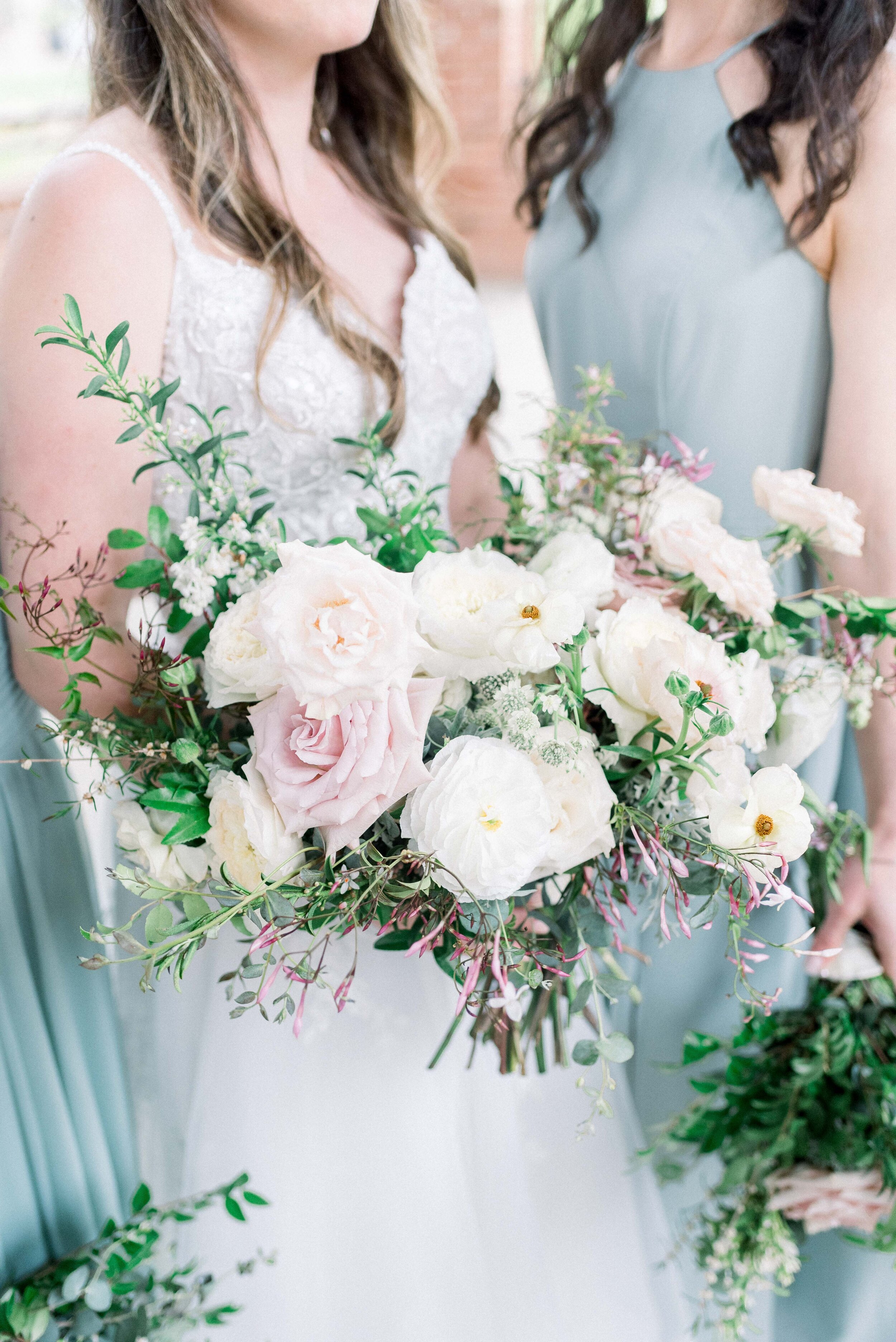 Champagne roses, cream garden roses, trailing jasmine, fluffy ranunculus, quicksand roses, majolica spray roses, and sage eucalyptus make up this gorgeous bridal bouquet. Designed by florist Rosemary & Finch in Nashville, TN.