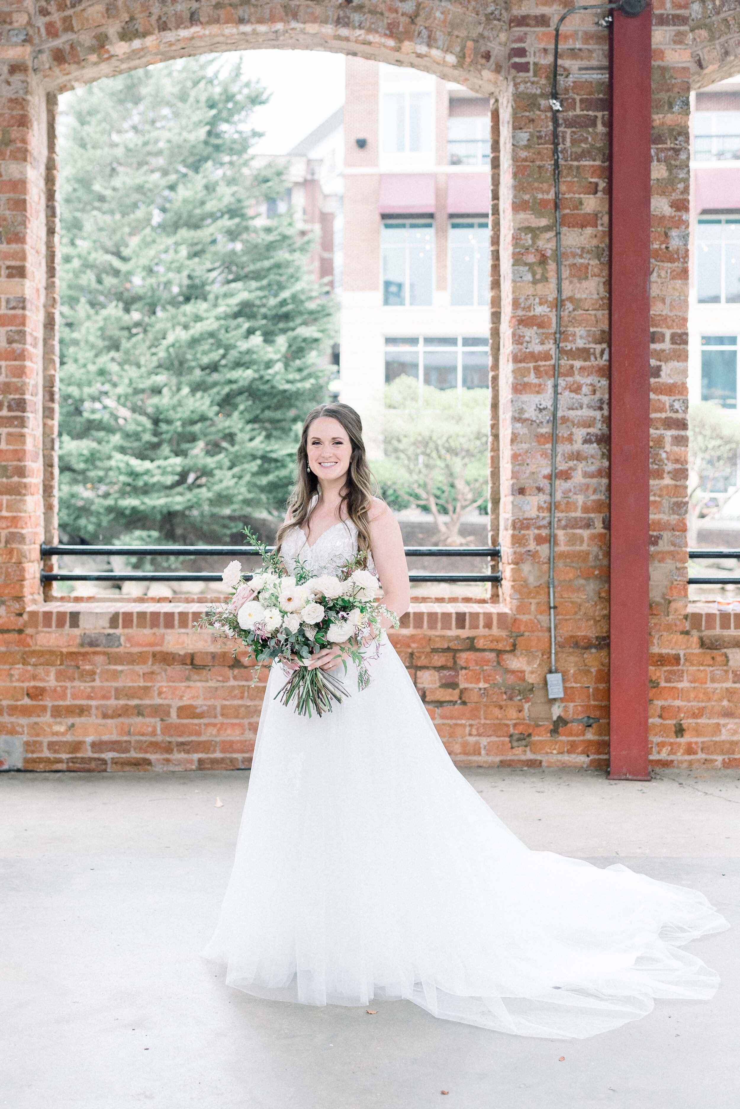 Champagne roses, cream garden roses, trailing jasmine, fluffy ranunculus, quicksand roses, majolica spray roses, and sage eucalyptus make up this gorgeous bridal bouquet. Designed by florist Rosemary & Finch in Nashville, TN.