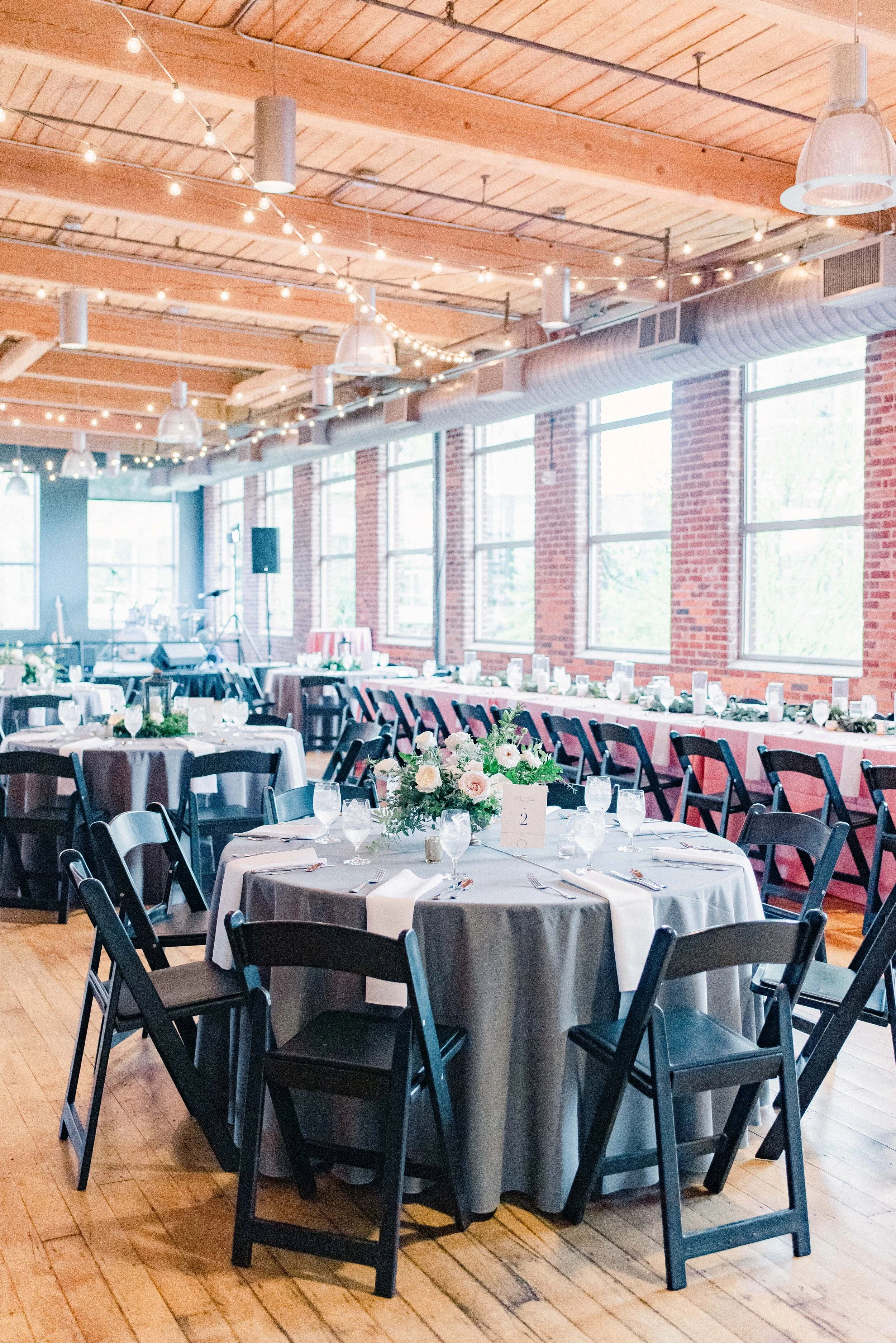 Table decor for this stunning wedding consisted of several different components. Round tables held lanterns adorned with blush and cream roses and lush greenery. Long, farm tables had garlands of eucalyptus and twinkling candles. Centerpieces filled…