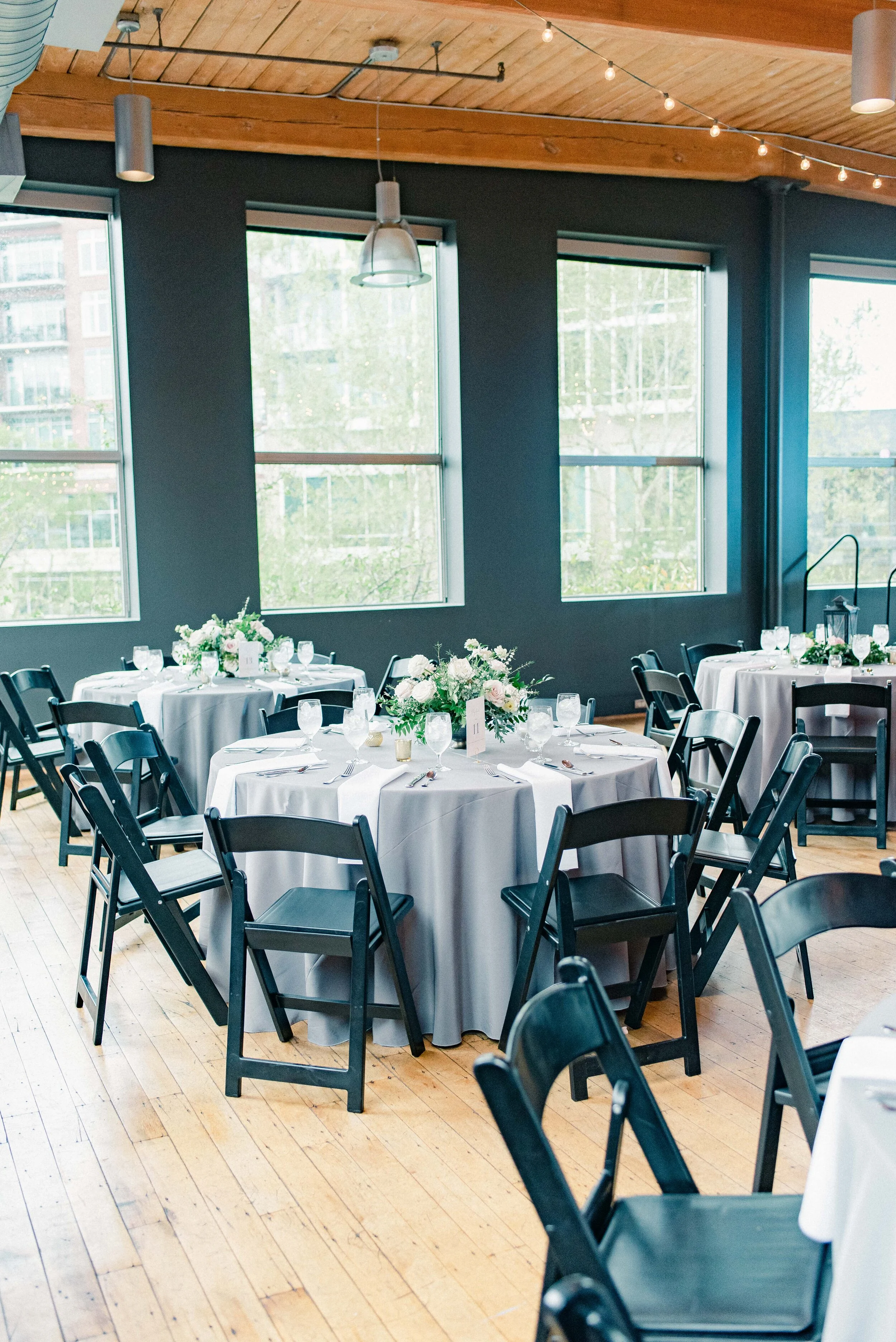 Table decor for this stunning wedding consisted of several different components. Round tables held lanterns adorned with blush and cream roses and lush greenery. Long, farm tables had garlands of eucalyptus and twinkling candles. Centerpieces filled…