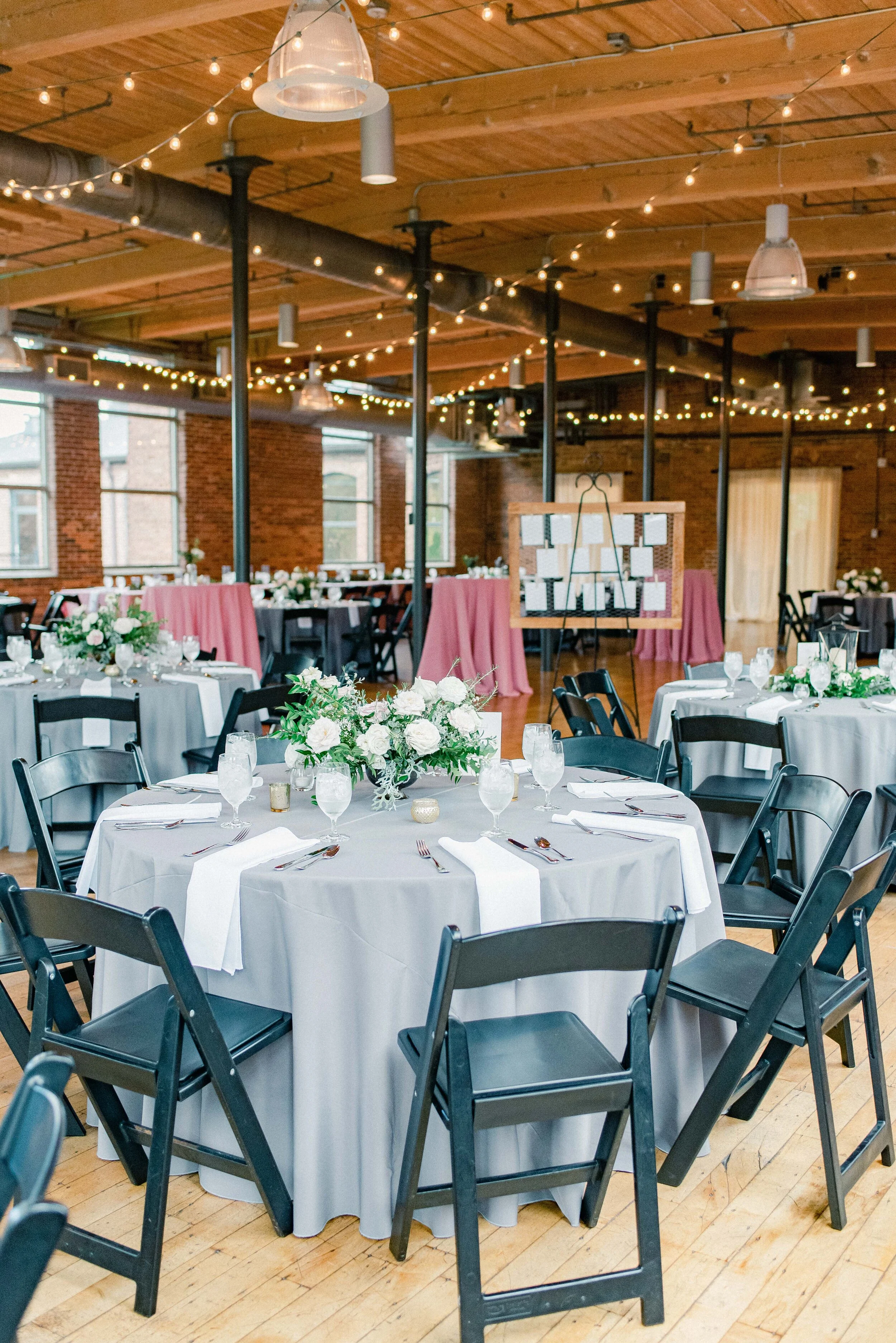 Table decor for this stunning wedding consisted of several different components. Round tables held lanterns adorned with blush and cream roses and lush greenery. Long, farm tables had garlands of eucalyptus and twinkling candles. Centerpieces filled…