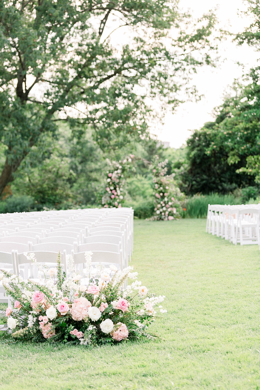 A fairytail arch filled with blush and ivory garden roses, majolica spray roses, champagne roses, eleagnus, and lush sprawling greenery. Designed by Rosemary & Finch in Nashville, TN.