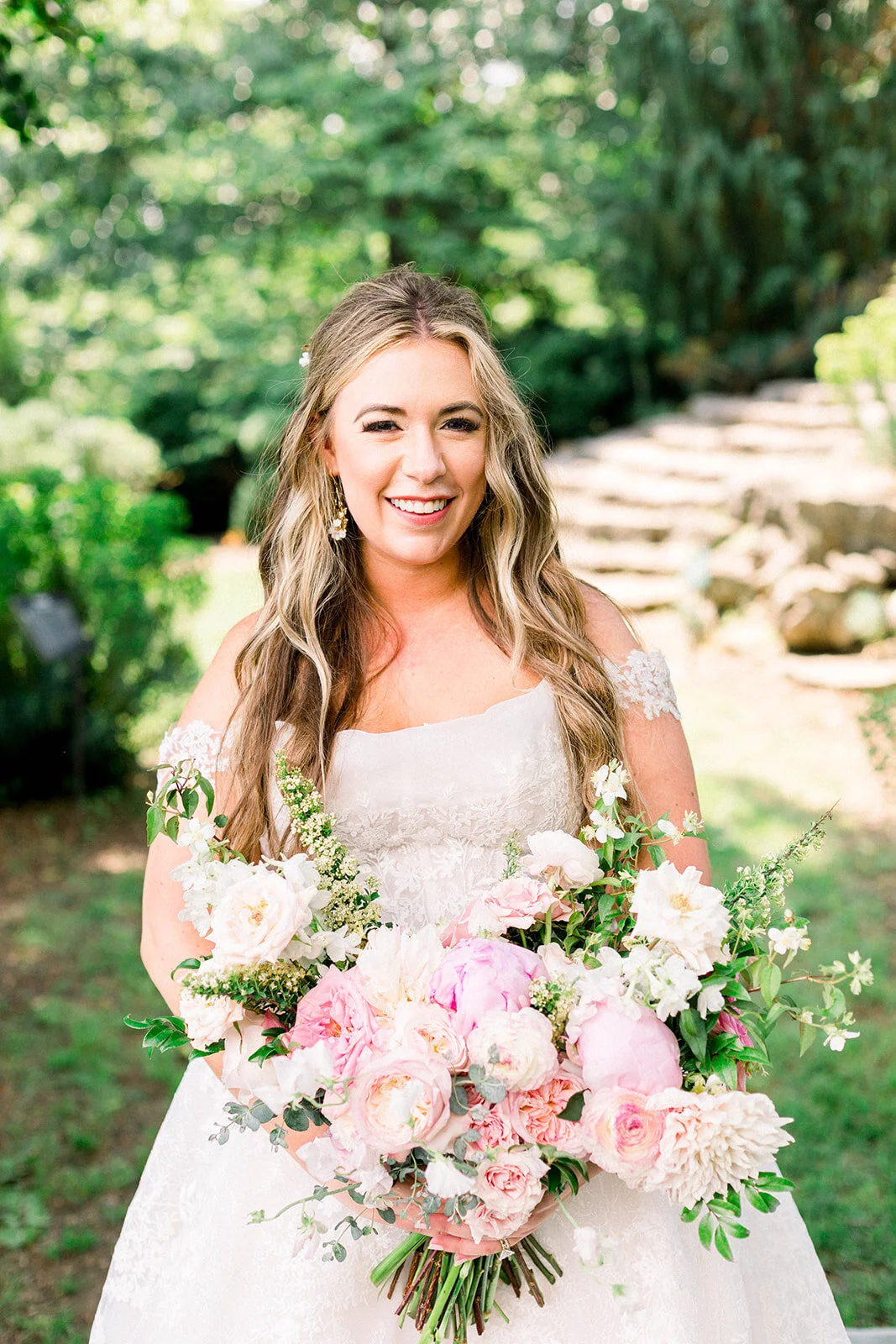 A lush bridal bouquet filled with hues of blush, pink, and ivory. Garden roses, majolica spray roses, champagne roses, peonies, picotee ranunculus, and spirea make up this fairytale bouquet. Designed by Rosemary & Finch in Nashville, TN.
