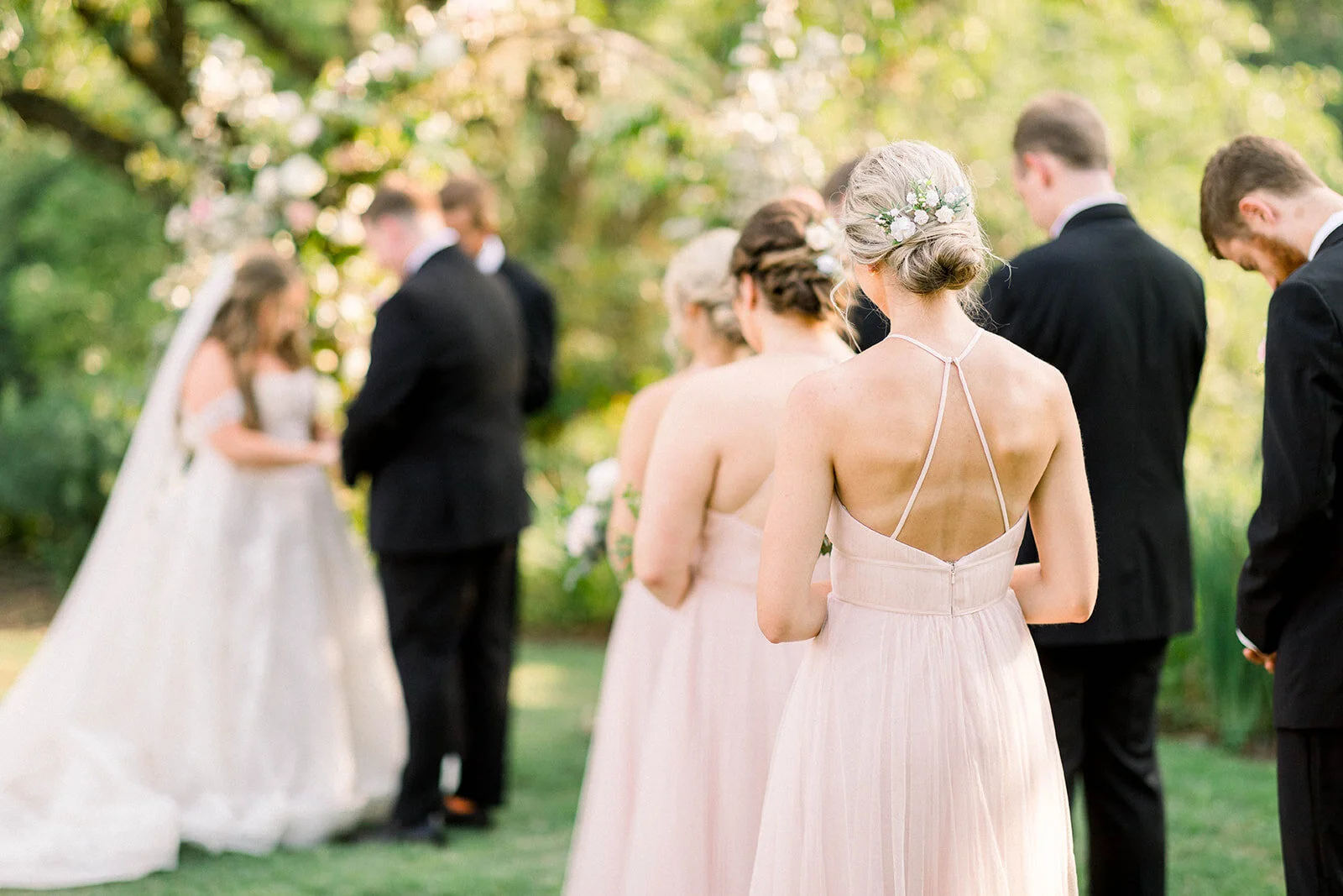 A fairytail arch filled with blush and ivory garden roses, majolica spray roses, champagne roses, eleagnus, and lush sprawling greenery. Designed by Rosemary & Finch in Nashville, TN.