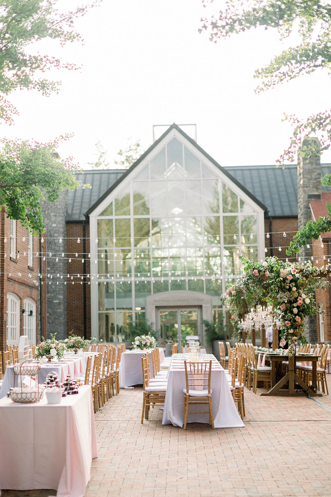 This garden courtyard reception pergola is covered with pink and ivory roses, majolica spray roses, heirloom carnations, assorted hydrangea and  cherry laurel. Designed by Rosemary & Finch in Nashville, TN.