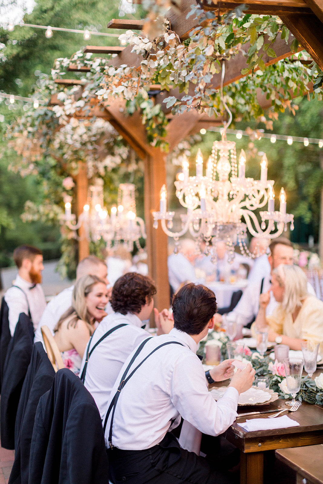 This garden courtyard reception pergola is covered with pink and ivory roses, majolica spray roses, heirloom carnations, assorted hydrangea and  cherry laurel. Designed by Rosemary & Finch in Nashville, TN.