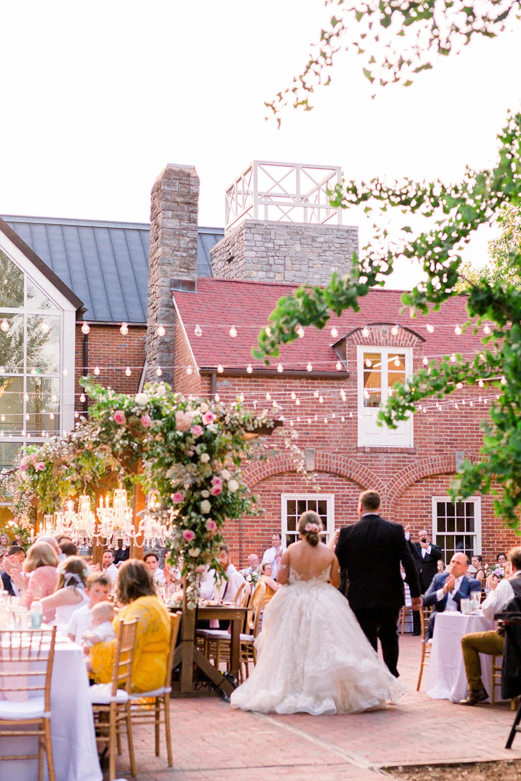 This garden courtyard reception pergola is covered with pink and ivory roses, majolica spray roses, heirloom carnations, assorted hydrangea and  cherry laurel. Designed by Rosemary & Finch in Nashville, TN.