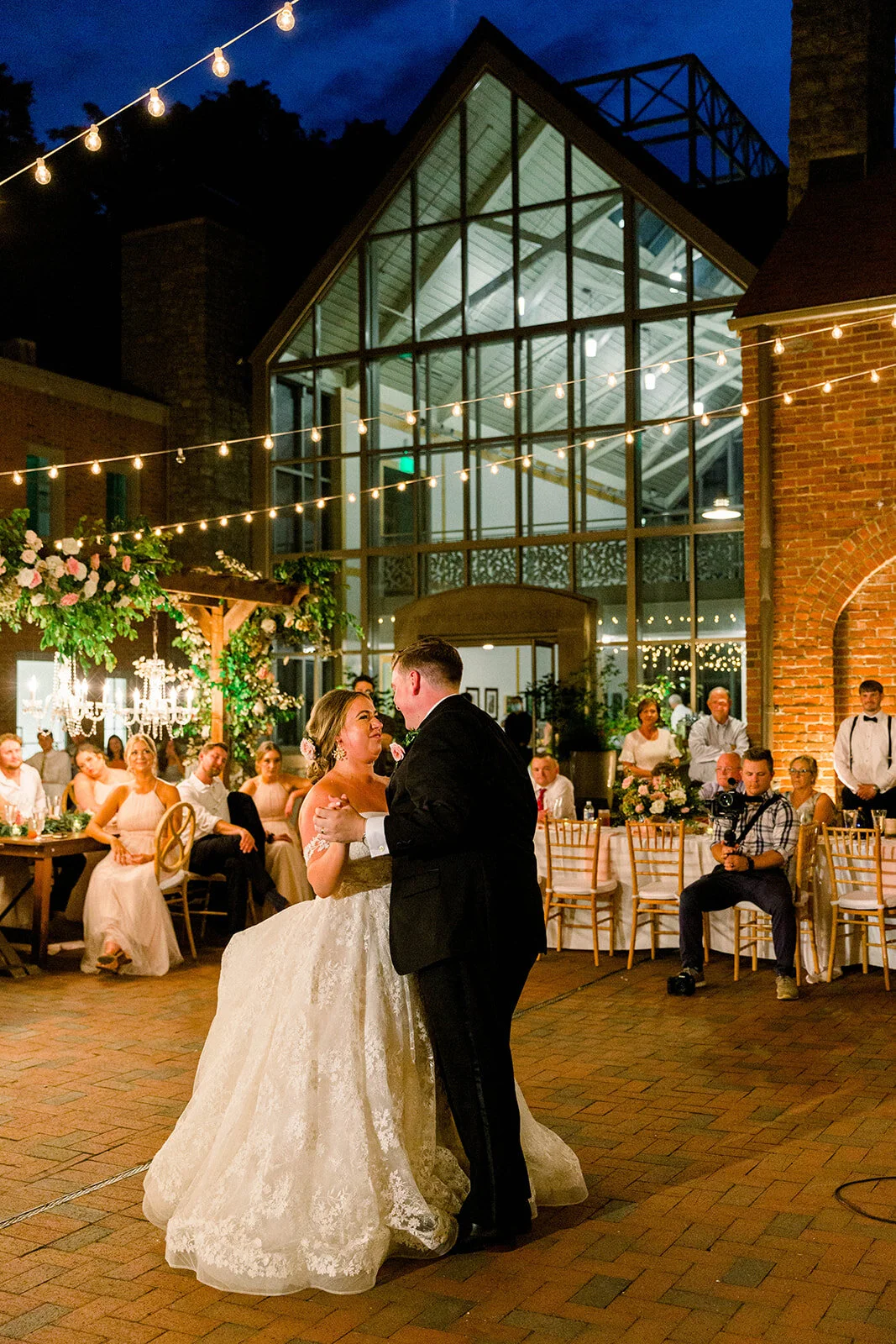 This garden courtyard reception pergola is covered with pink and ivory roses, majolica spray roses, heirloom carnations, assorted hydrangea and  cherry laurel. Designed by Rosemary & Finch in Nashville, TN.