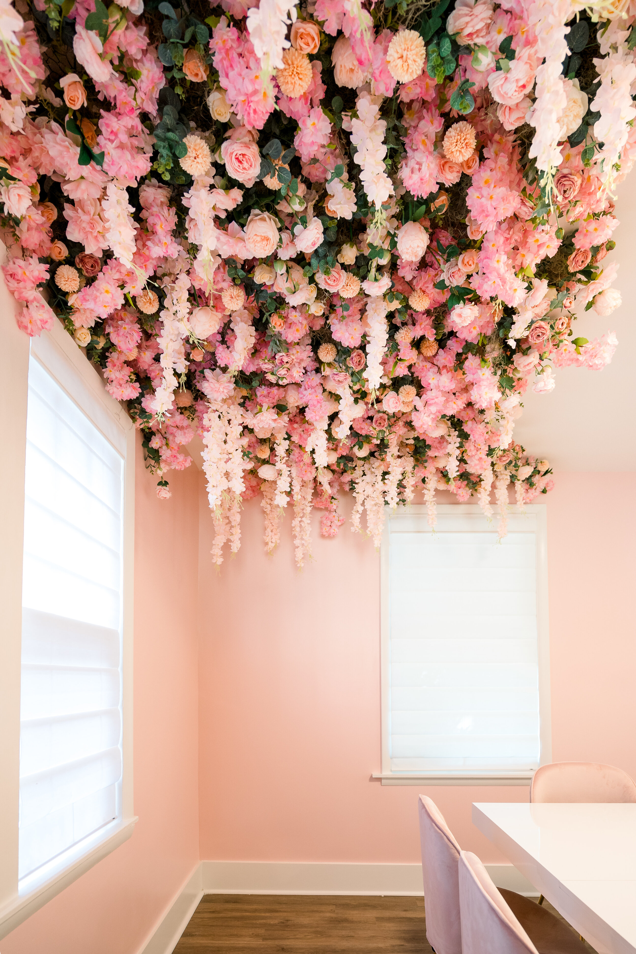 This bachelorette airbnb has a semi permanent ceiling installation full of faux cherry blossom, blush dahlias, pink roses, hanging wisteria, and spanish moss. Designed by florist Rosemary & Finch in Nashville, TN.