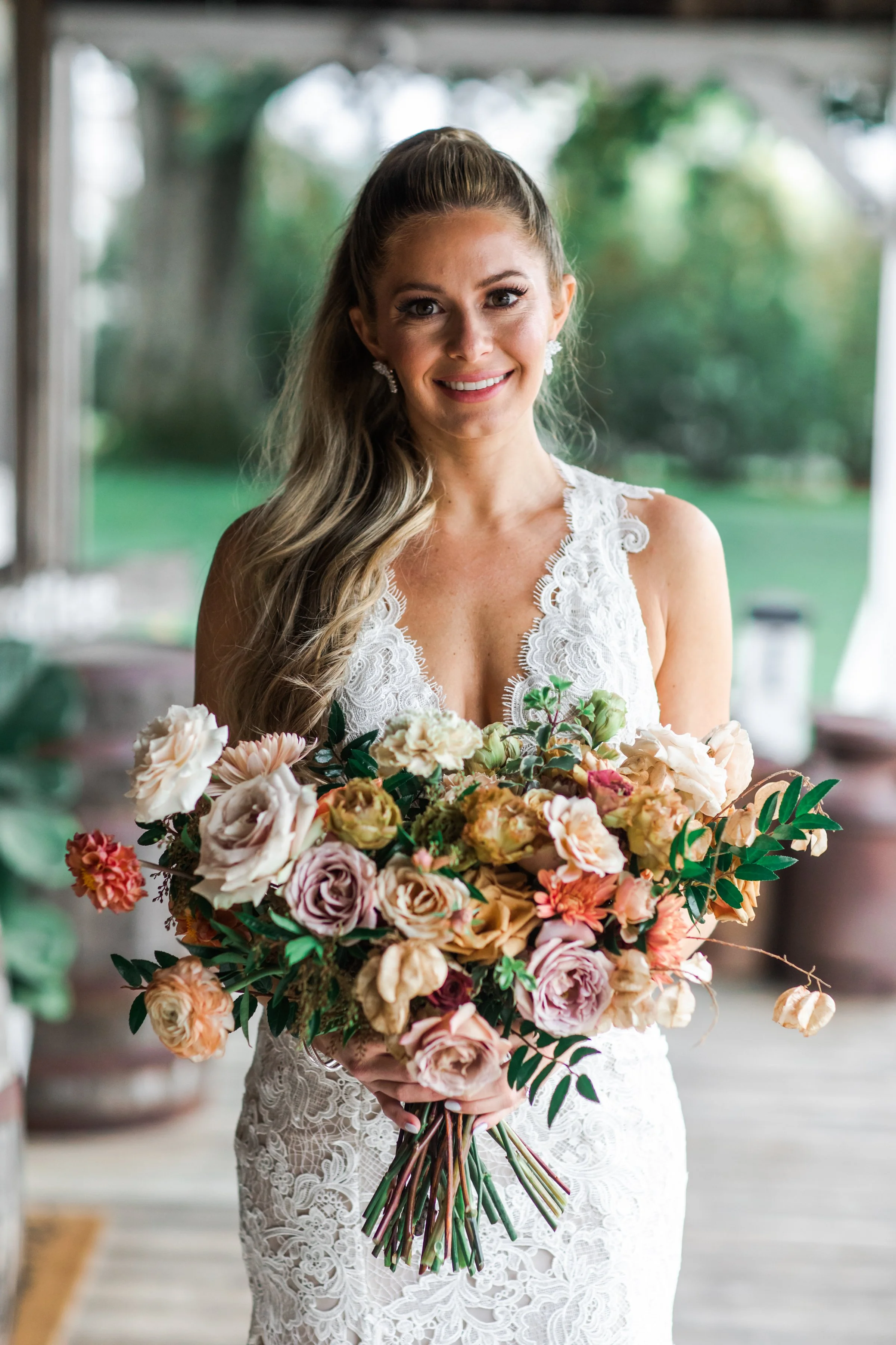An elegant fall bridal bouquet featuring a sunset color palette of blush, terra cotta, rose gold, yellow, and copper. Florals accents of dahlias, garden roses, ranunculus, and double brownie tulips. Designed by Rosemary and Finch in Nashville, TN.