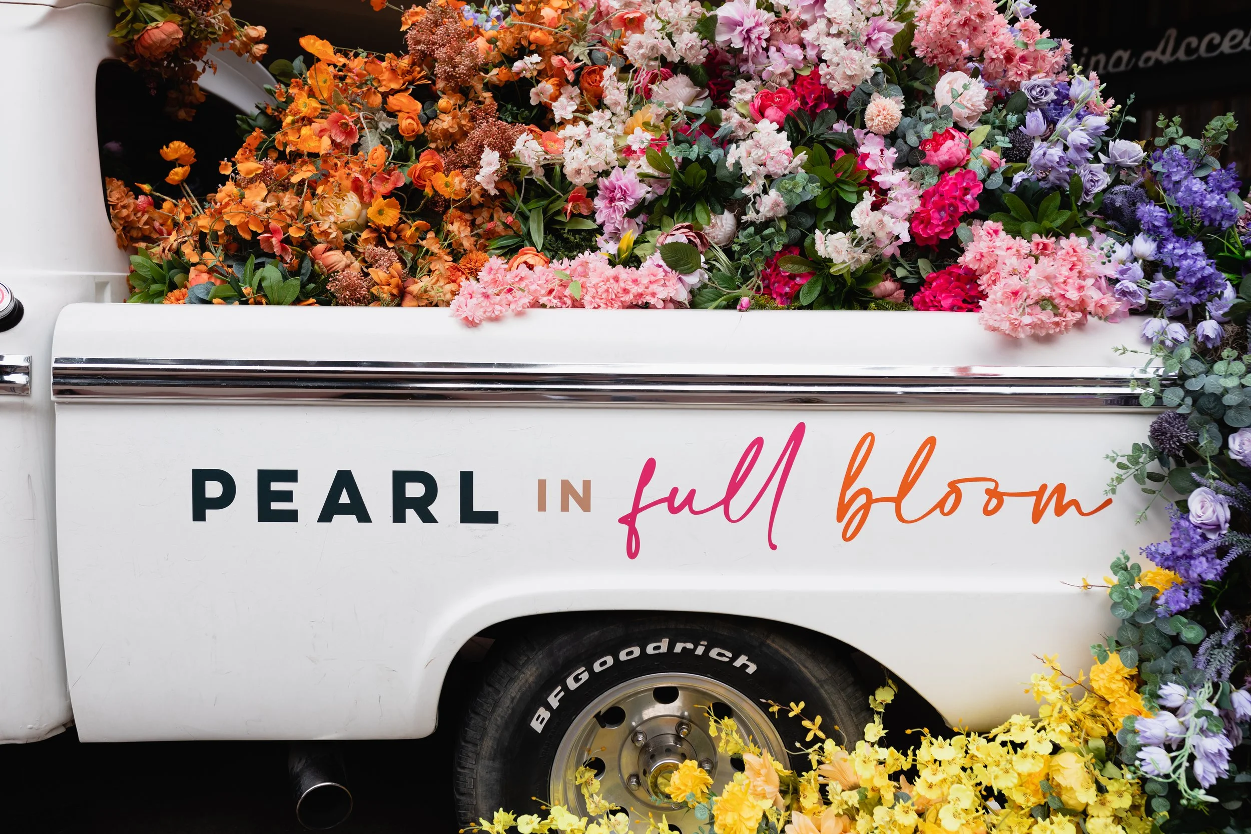 Cheerful pickup truck installation composed of silk floral hues in pink, magenta, lavender, coral, orange, yellow, and mixed greens bring to life this spring Fifth + Broadway event in Nashville, TN. Design by Rosemary and Finch.