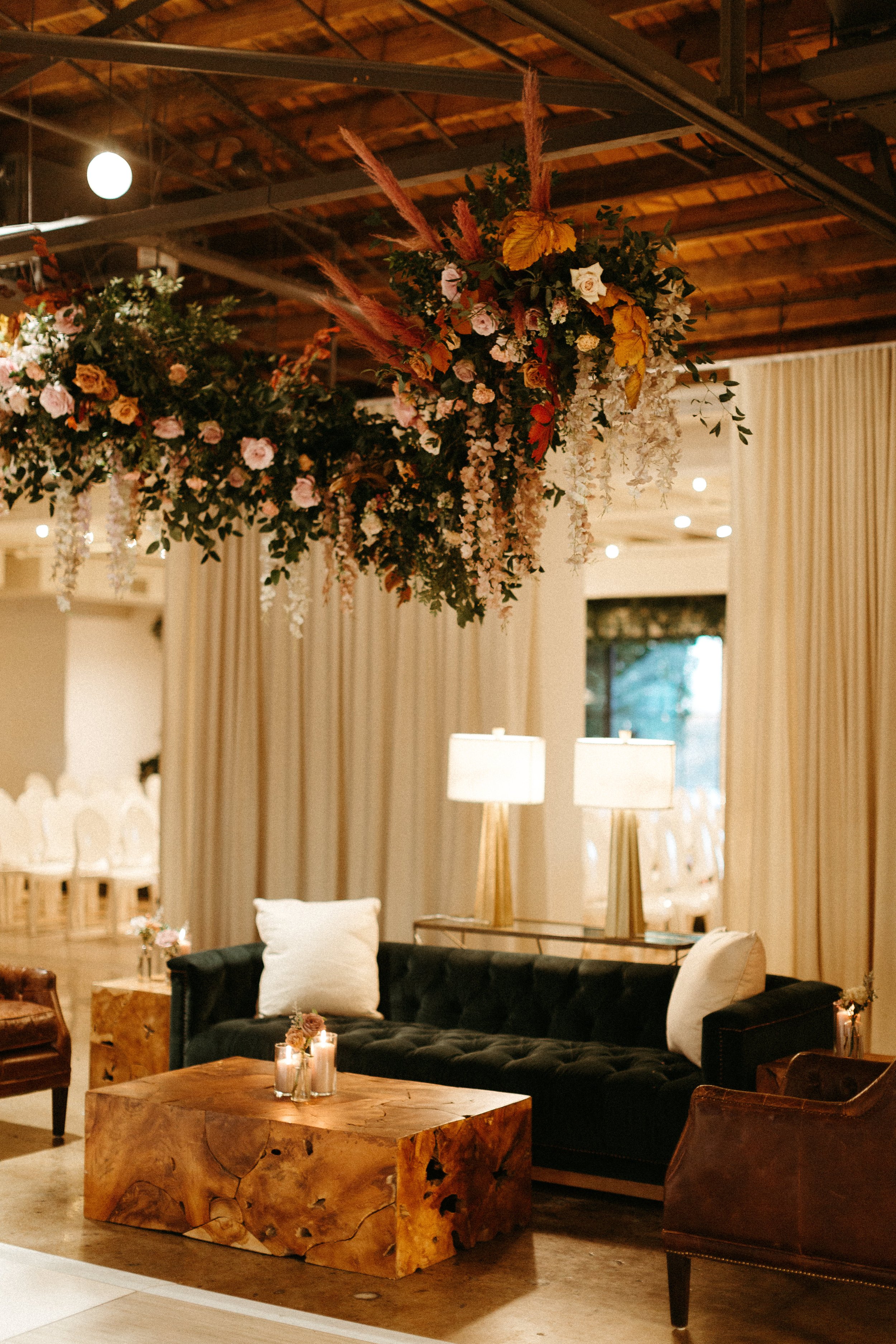 Stunning floral installations bring warmth to this Great Gatsby inspired wedding with florals of terra cotta, dusty pink, and burgundy hues. Petal heavy roses, wisteria, copper beech, and pink pampas grass accents. Designed by Rosemary and Finch in N