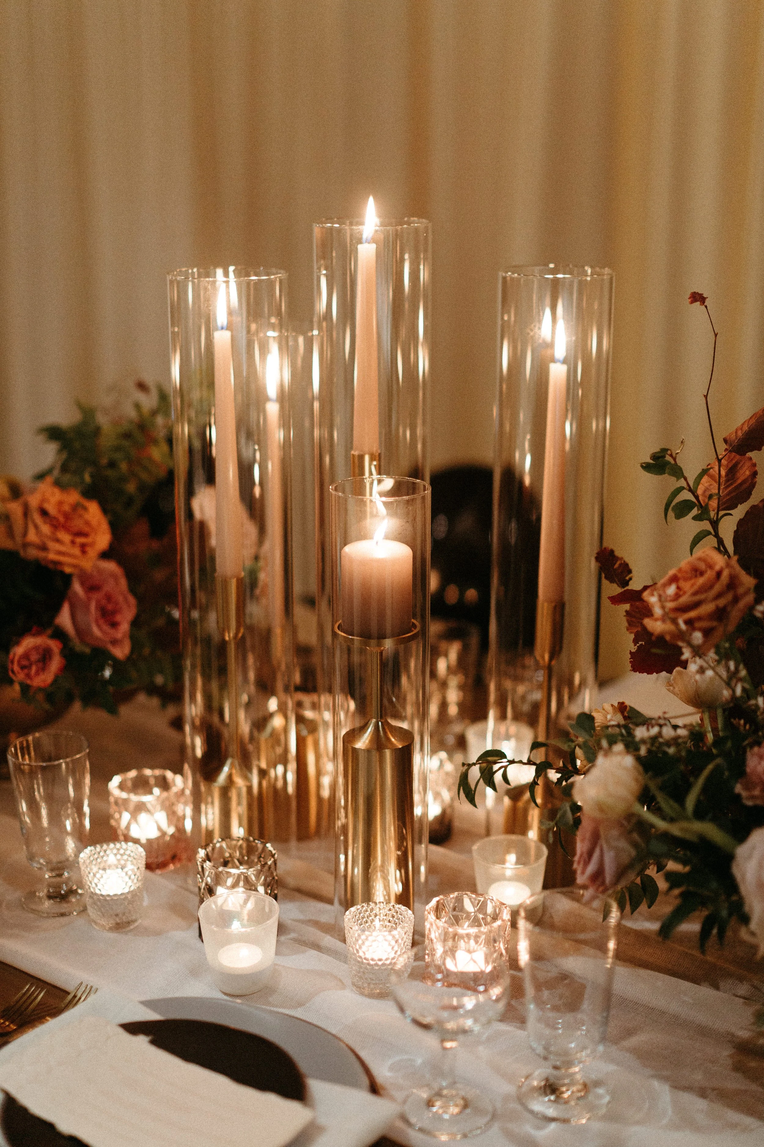 1920s and Great Gatsby inspired tablescapes are highlighted by gorgeous gold candlesticks, blush tapers, and taupe and bronze votives. Designed with floral hues of terra cotta, mauve, and dusty rose. Designed by Rosemary and Finch in Nashville, TN.