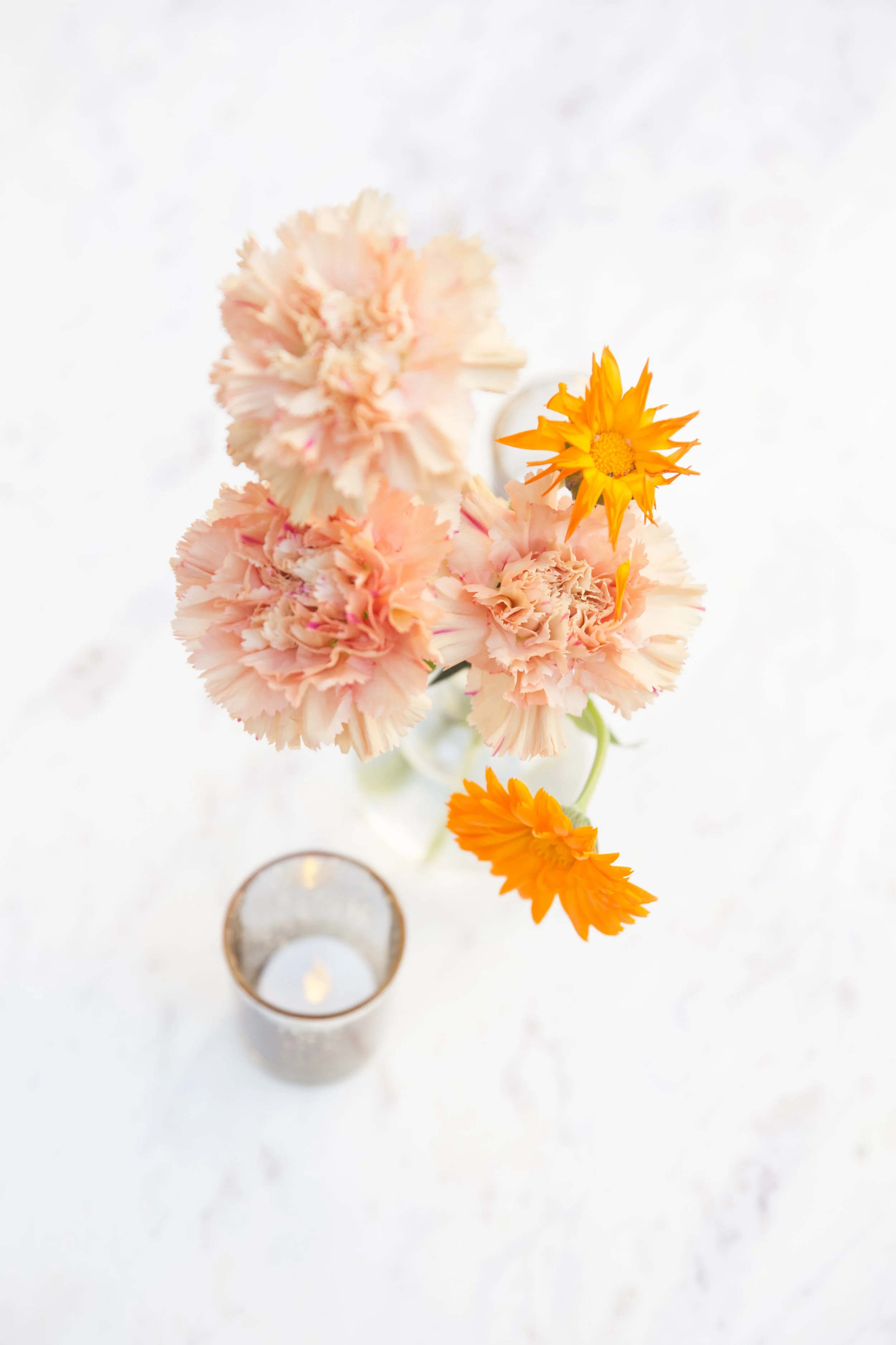 Bright dainty bud vases accent the welcome space of the War Memorial Auditorium in Nashville, TN. Following a color block theme comprised of hydrangeas, carnations, roses, and pampas grass. TPAC Gala designed by Rosemary and Finch.