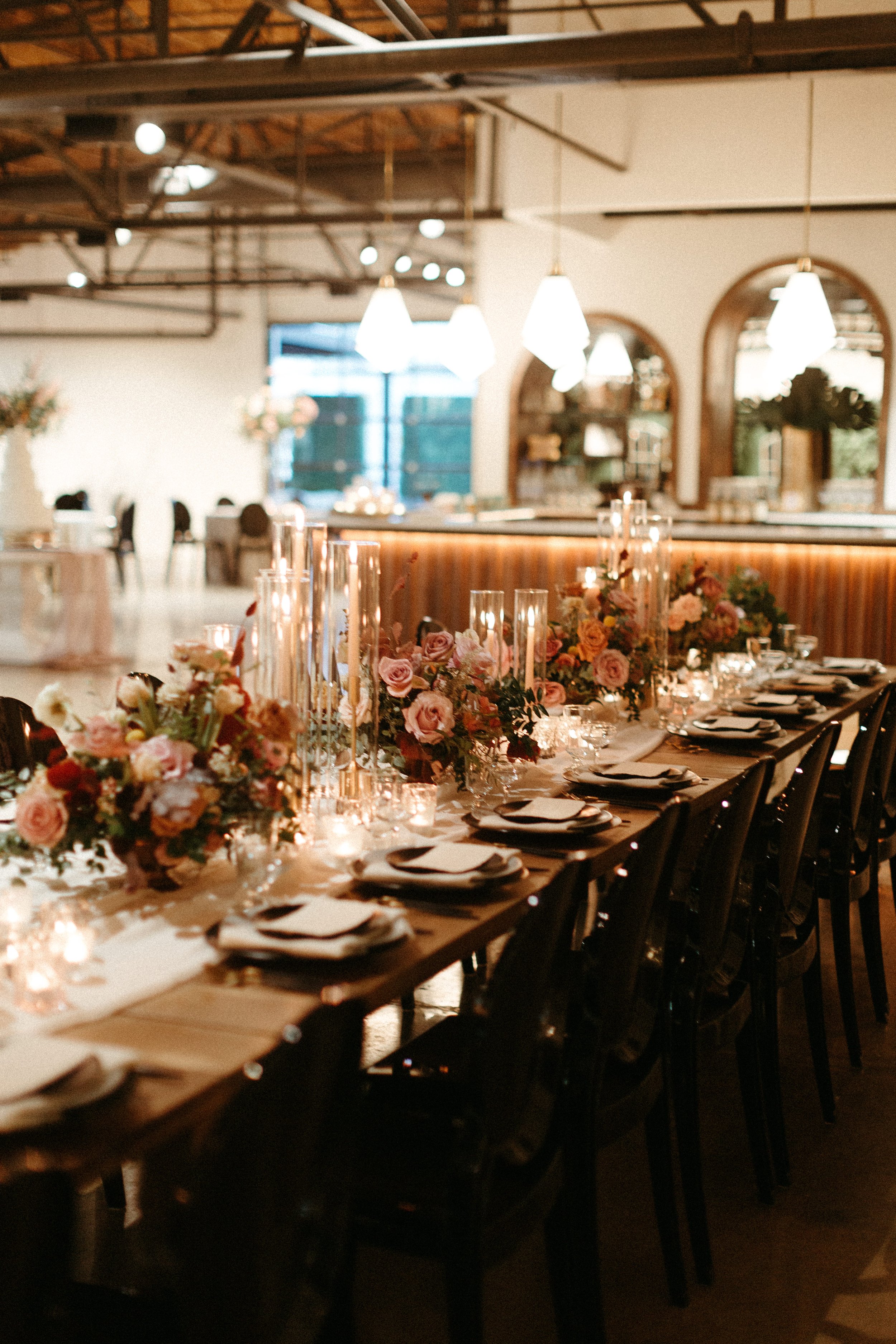 Gorgeous centerpieces bring warmth to this art deco 1920s inspired wedding with hues of terra cotta, dusty pink, mauve, and burgundy. Lush roses, ranunculus, and copper beech highlight the florals. Designed by Rosemary and Finch in Nashville, TN.