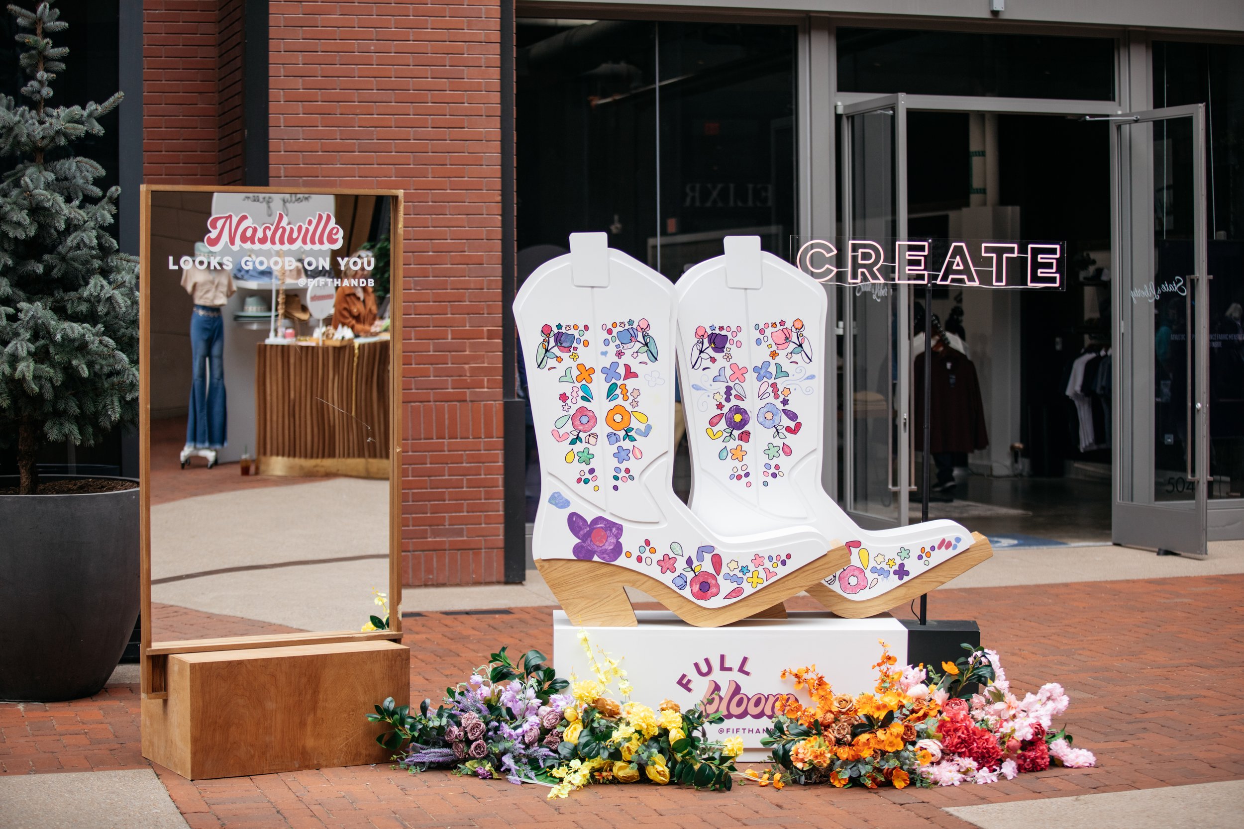 Vibrant floral installations composed of silk floral hues in pink, magenta, lavender, coral, orange, yellow, and mixed greens bring to life this spring Fifth + Broadway event in Nashville, TN. Design by Rosemary and Finch.
