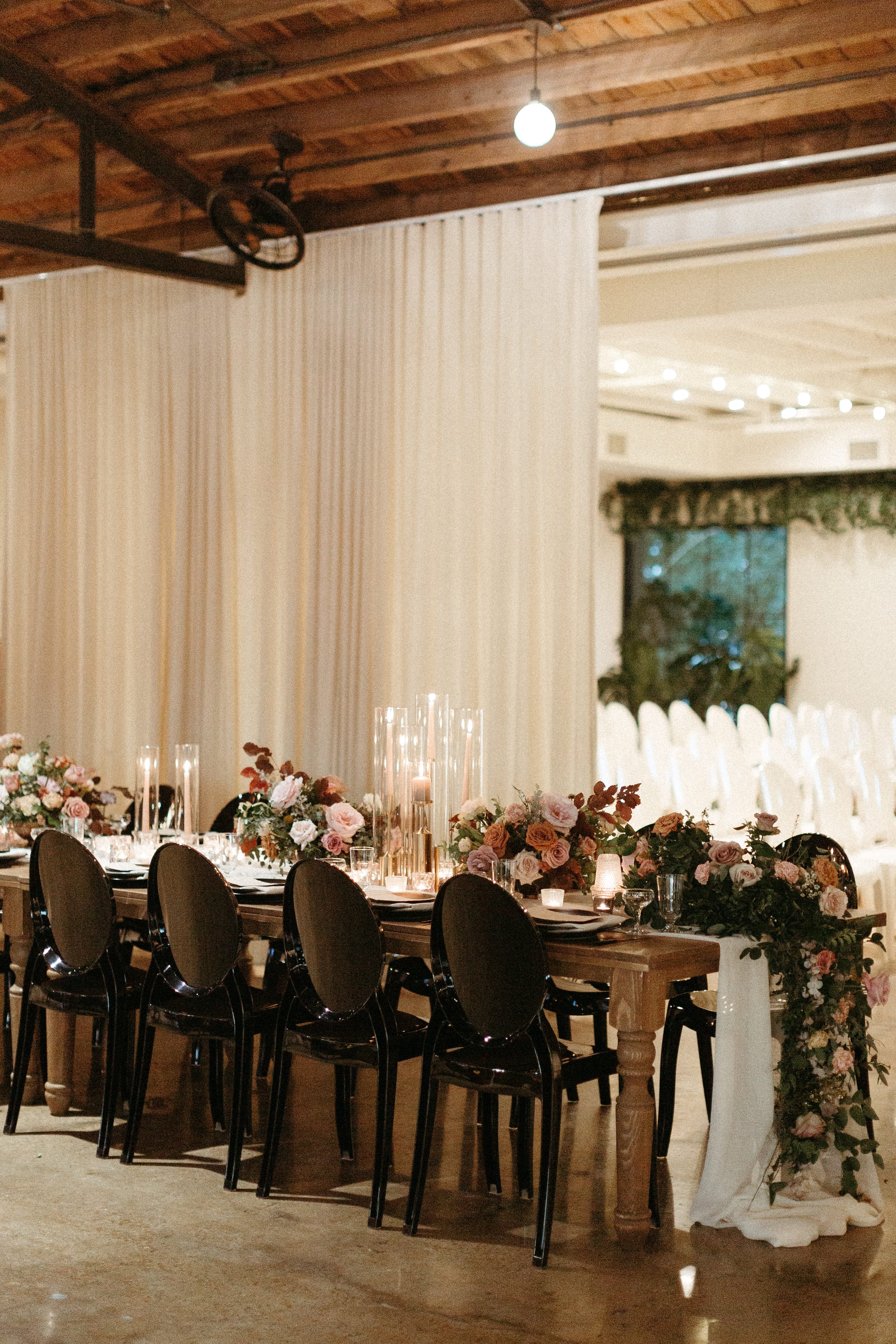Gorgeous centerpieces bring warmth to this art deco 1920s inspired wedding with hues of terra cotta, dusty pink, mauve, and burgundy. Lush roses, ranunculus, and copper beech highlight the florals. Designed by Rosemary and Finch in Nashville, TN.