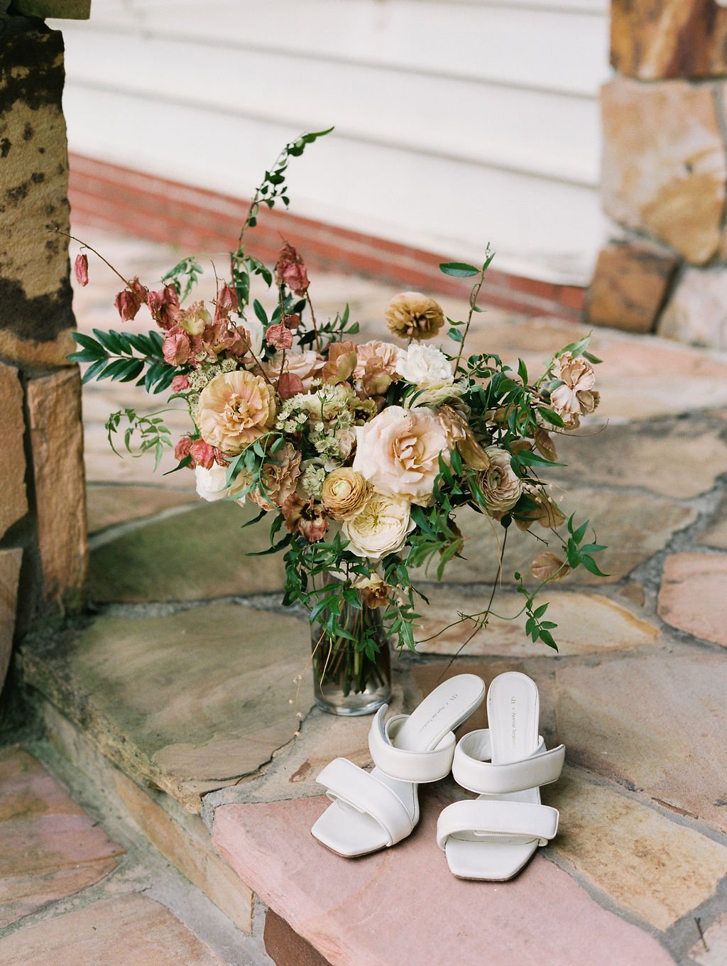 Lush bridal bouquet with dusty rose and copper flowers including garden roses, ranunculus, dried flowers, and natural greenery. Nashville wedding floral designer at RT Lodge.