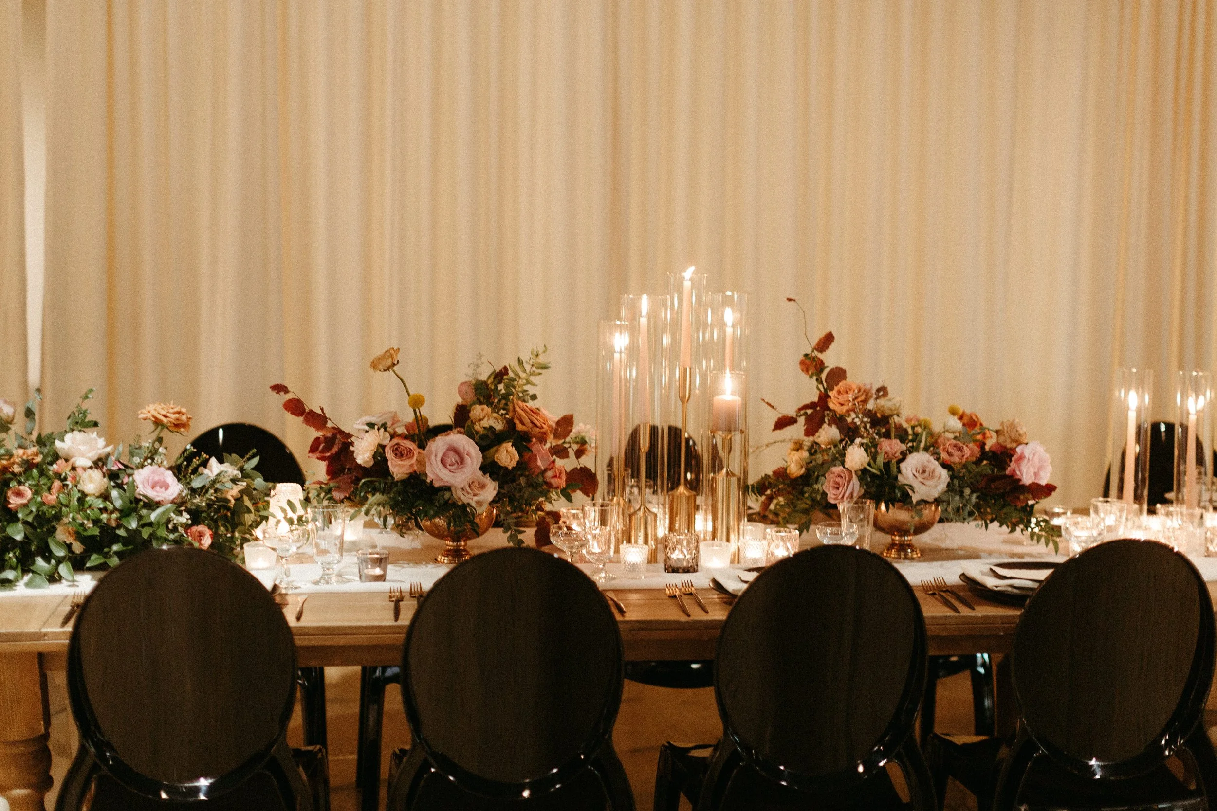 Gorgeous centerpieces bring warmth to this art deco 1920s inspired wedding with hues of terra cotta, dusty pink, mauve, and burgundy. Lush roses, ranunculus, and copper beech highlight the florals. Designed by Rosemary and Finch in Nashville, TN.