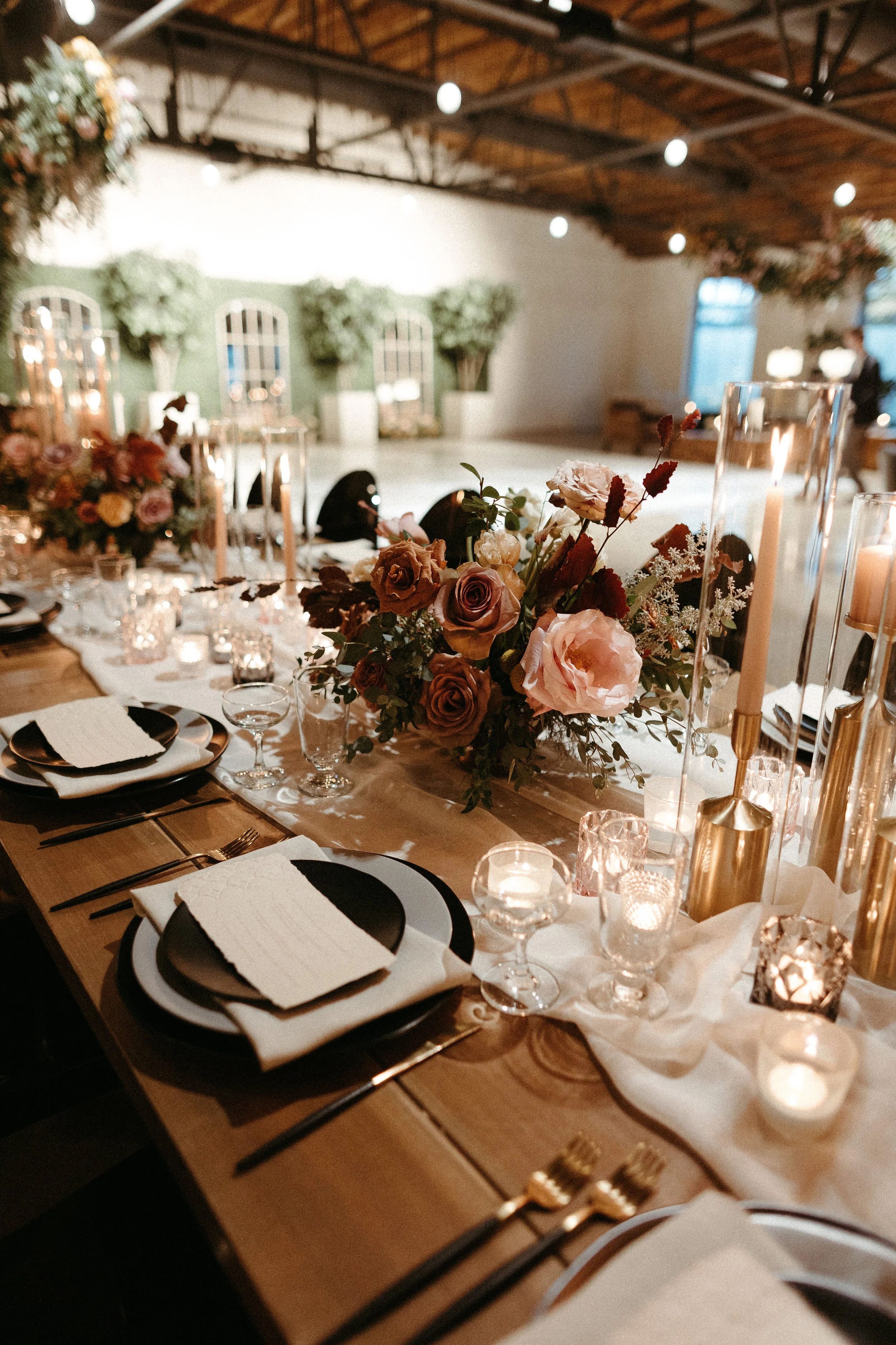 Gorgeous centerpieces bring warmth to this art deco 1920s inspired wedding with hues of terra cotta, dusty pink, mauve, and burgundy. Lush roses, ranunculus, and copper beech highlight the florals. Designed by Rosemary and Finch in Nashville, TN.