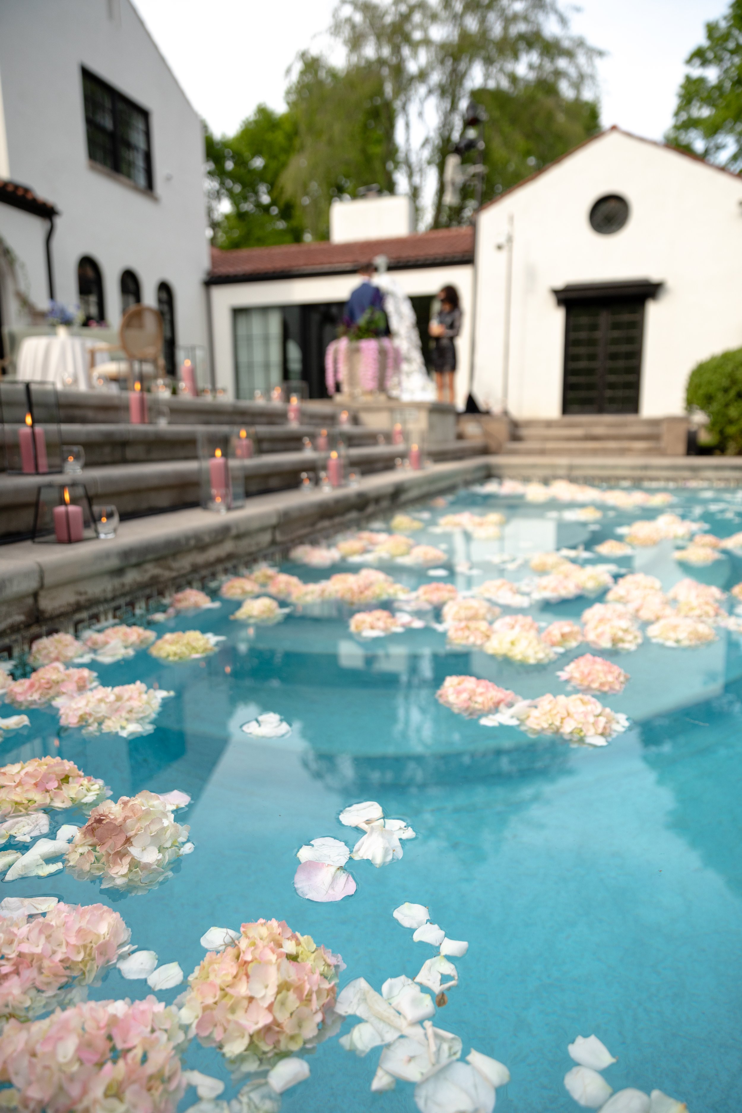 Bridgerton inspired engagement party at a private home in Nashville, TN with pastel candles and flowers floating in the pool.