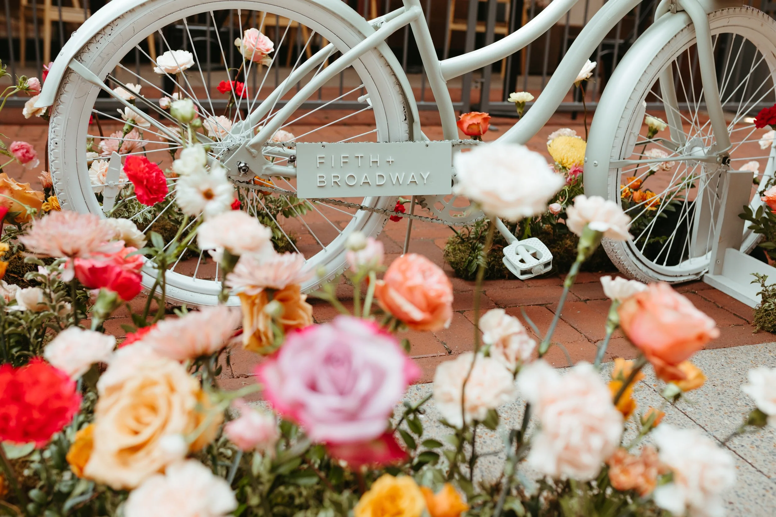 Vibrant floral installations composed of silk floral hues in pink, magenta, lavender, coral, orange, yellow, and mixed greens bring to life this spring Fifth + Broadway event in Nashville, TN. Design by Rosemary and Finch.