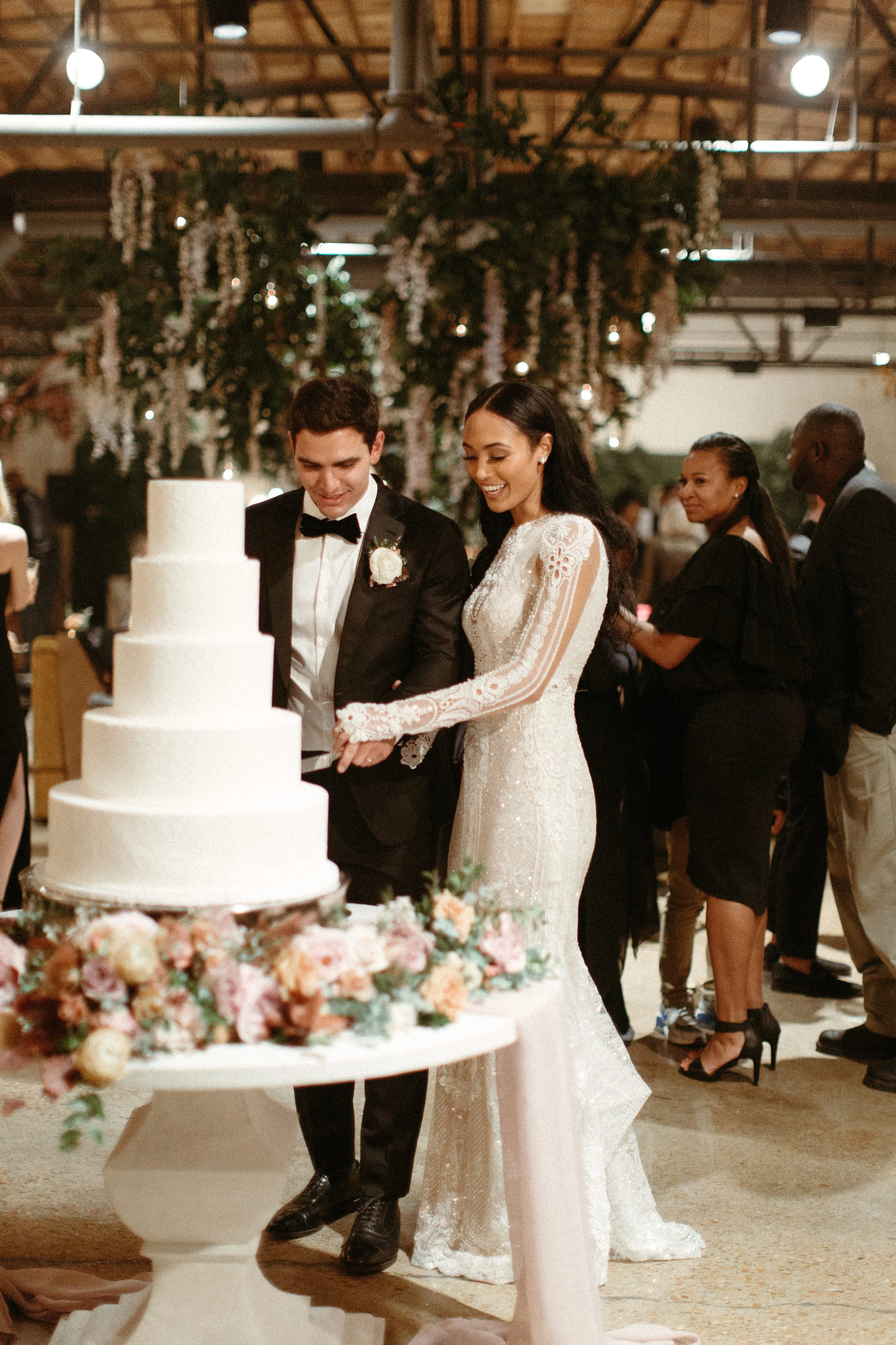 Elegant florals consisting of petal heavy roses in hues of mauve, dusty rose, terra cotta, and burgundy provide beautiful accents to this winter wedding’s cake table. Designed by Rosemary and Finch in Nashville, TN.