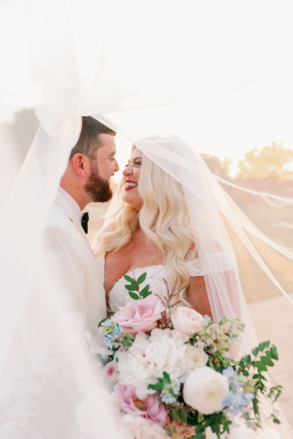 A lush bridal bouquet filled with hues of blush, pink, ivory, and hints of French blue. Garden roses, majolica spray roses, champagne roses, peonies, ranunculus, delphinium, and spirea make up this fairytale bouquet. Designed by Rosemary & Finch in N