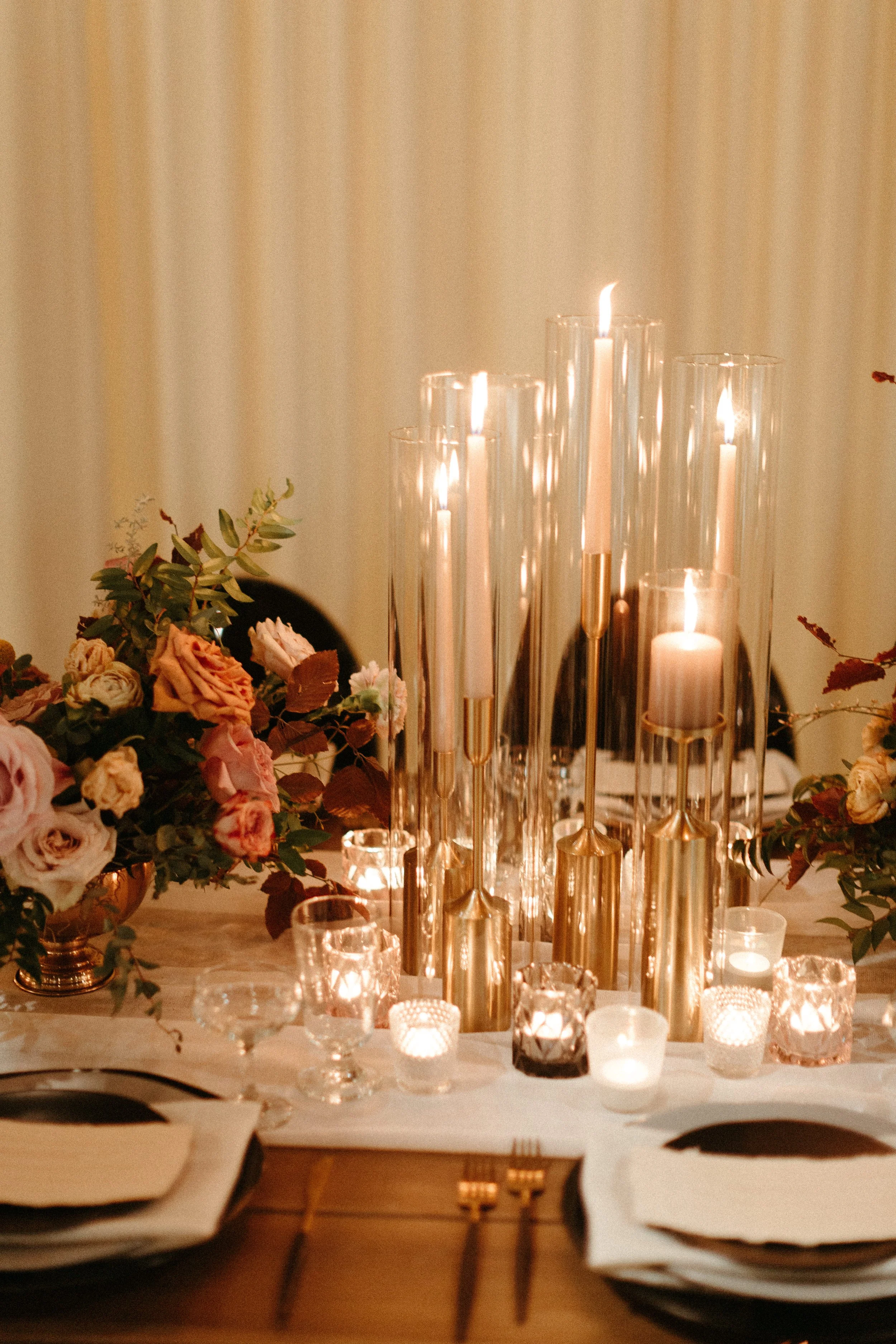 1920s and Great Gatsby inspired tablescapes are highlighted by gorgeous gold candlesticks, blush tapers, and taupe and bronze votives. Designed with floral hues of terra cotta, mauve, and dusty rose. Designed by Rosemary and Finch in Nashville, TN.