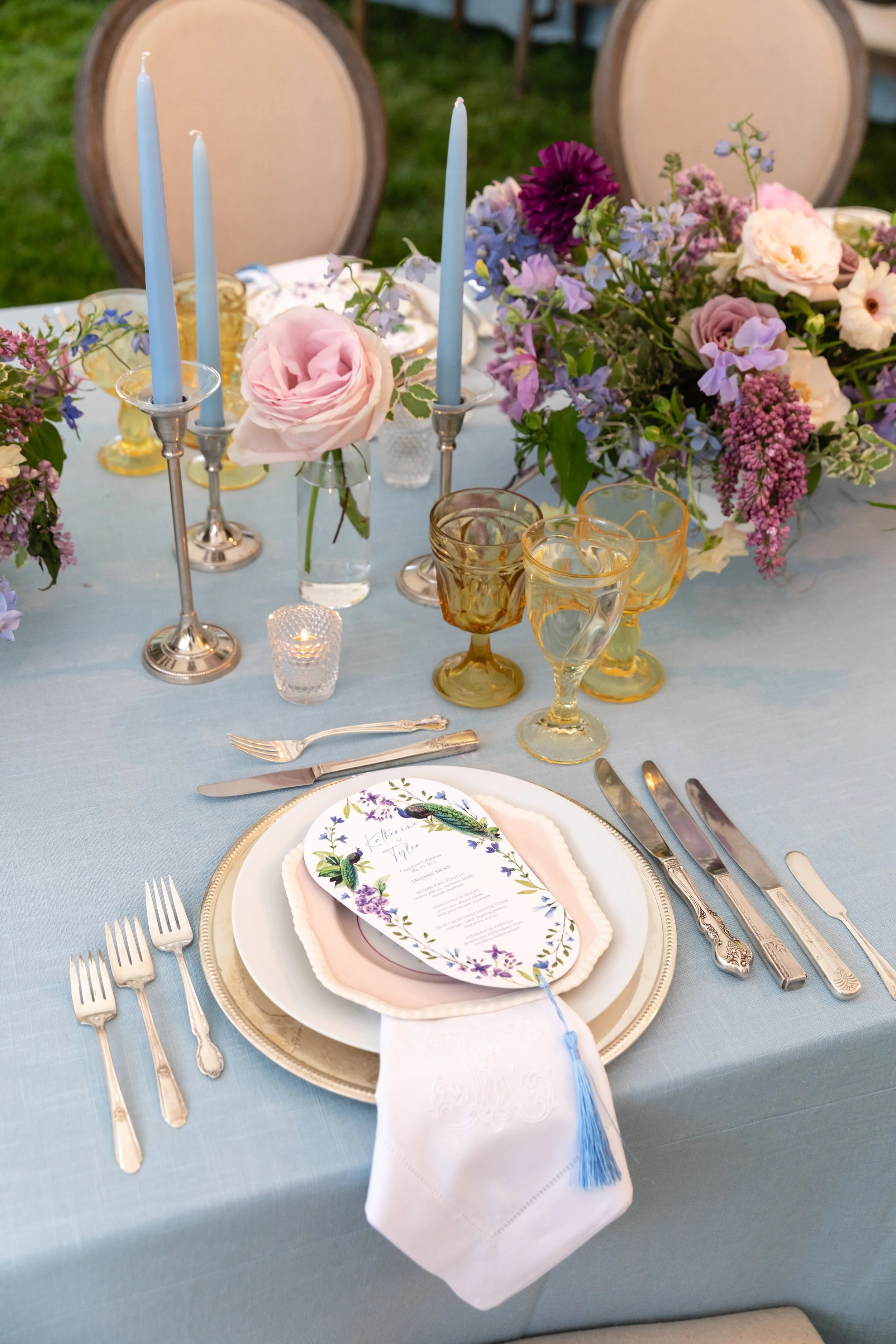 Growing, fresh floral centerpieces with blush garden roses, lilac, blue sweet peas, ranunculus, lavender delphinium, globe allium, clematis, and natural greenery for a tented Bridgerton inspired engagement party at a private home in Nashville, TN.
