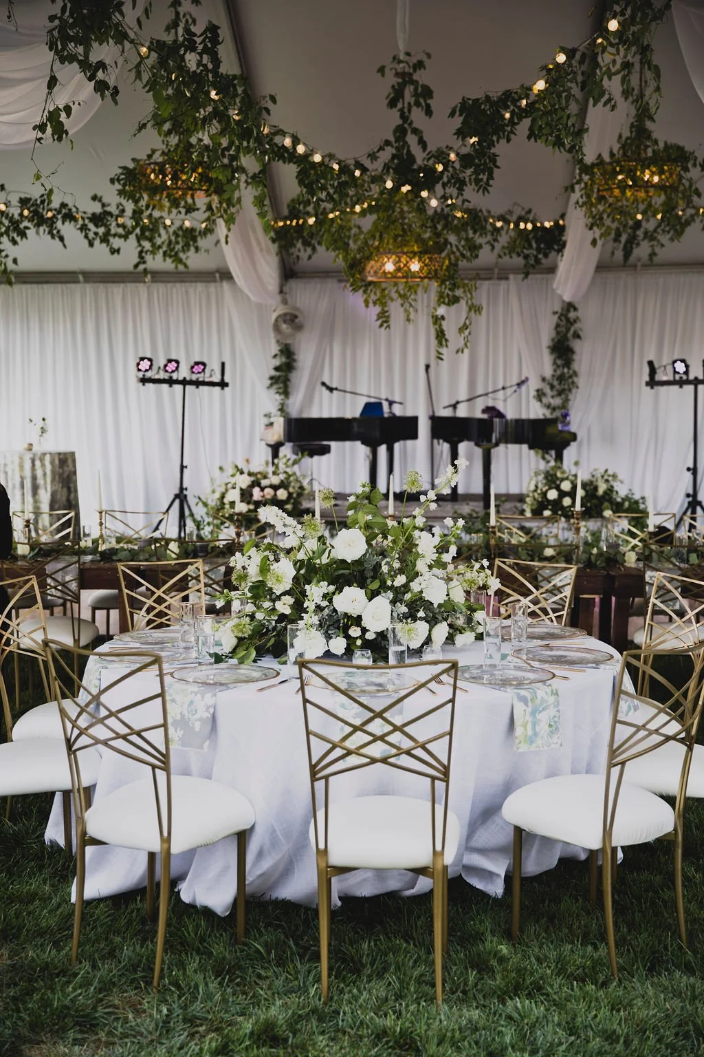 The centerpieces at this romantic summer wedding are filled with white ranunculus, garden roses, spray roses, delphinium, queen anne's lace, and lush greenery. Designed by Rosemary and Finch in Nashville, TN.