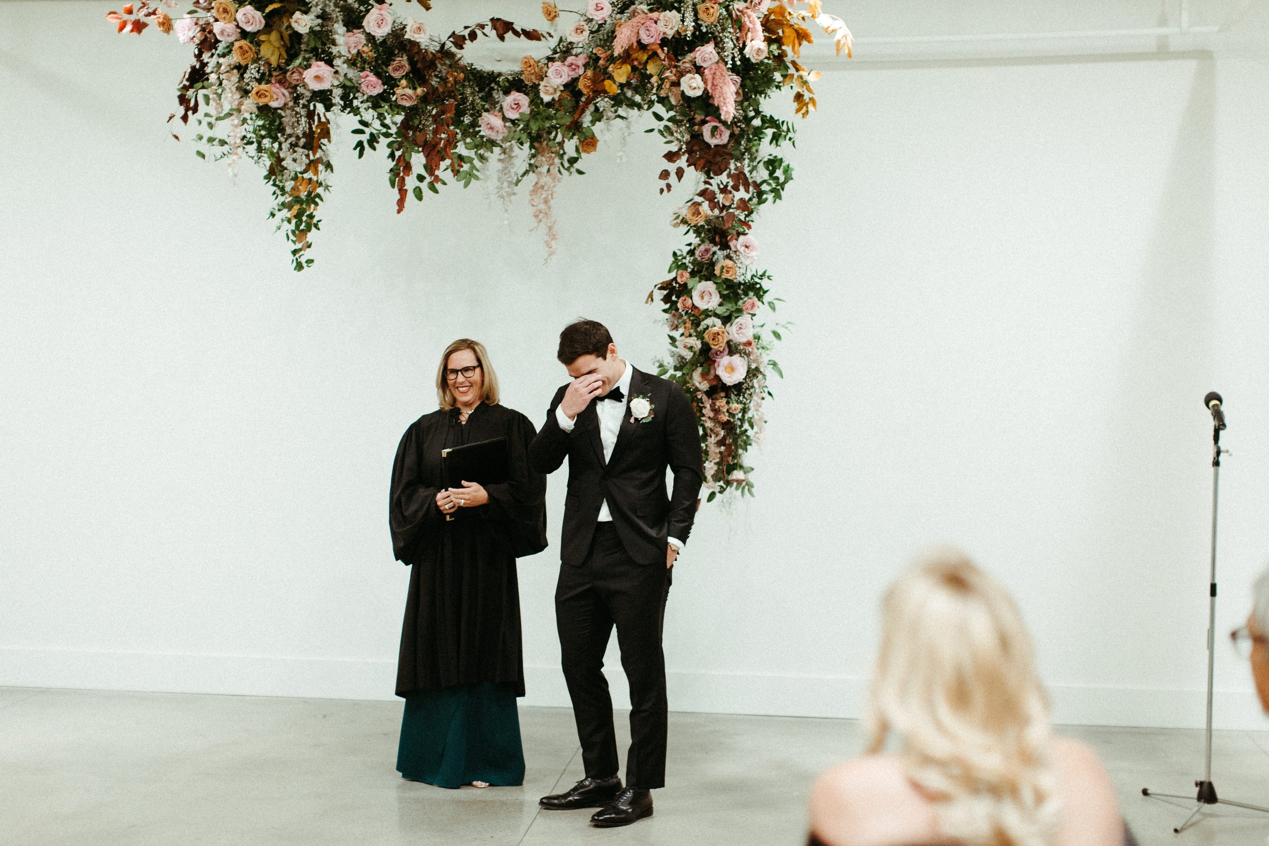 An eye-catching whimsical installation full of petal heavy roses and copper beech was the highlight of this art deco wedding. Terra cotta, burgundy, dusty pink, and other neutral florals warm up this ceremony. Designed by Rosemary and Finch in Nashvi