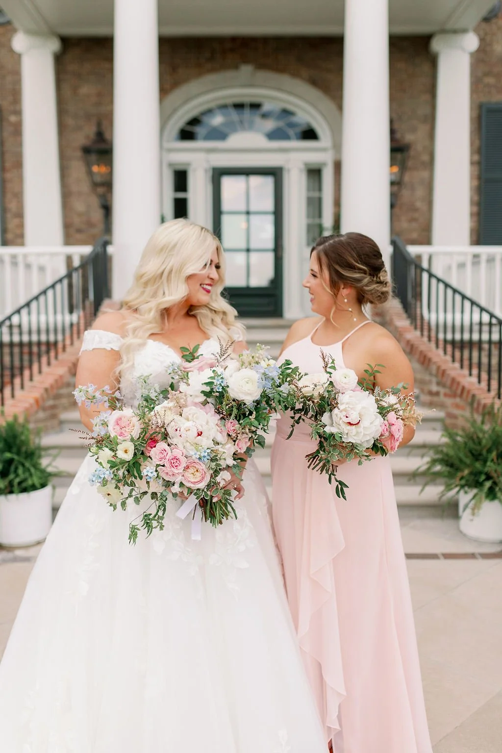 A lush bridal bouquet filled with hues of blush, pink, ivory, and hints of French blue. Garden roses, majolica spray roses, champagne roses, peonies, ranunculus, delphinium, and spirea make up this fairytale bouquet. Designed by Rosemary & Finch in N