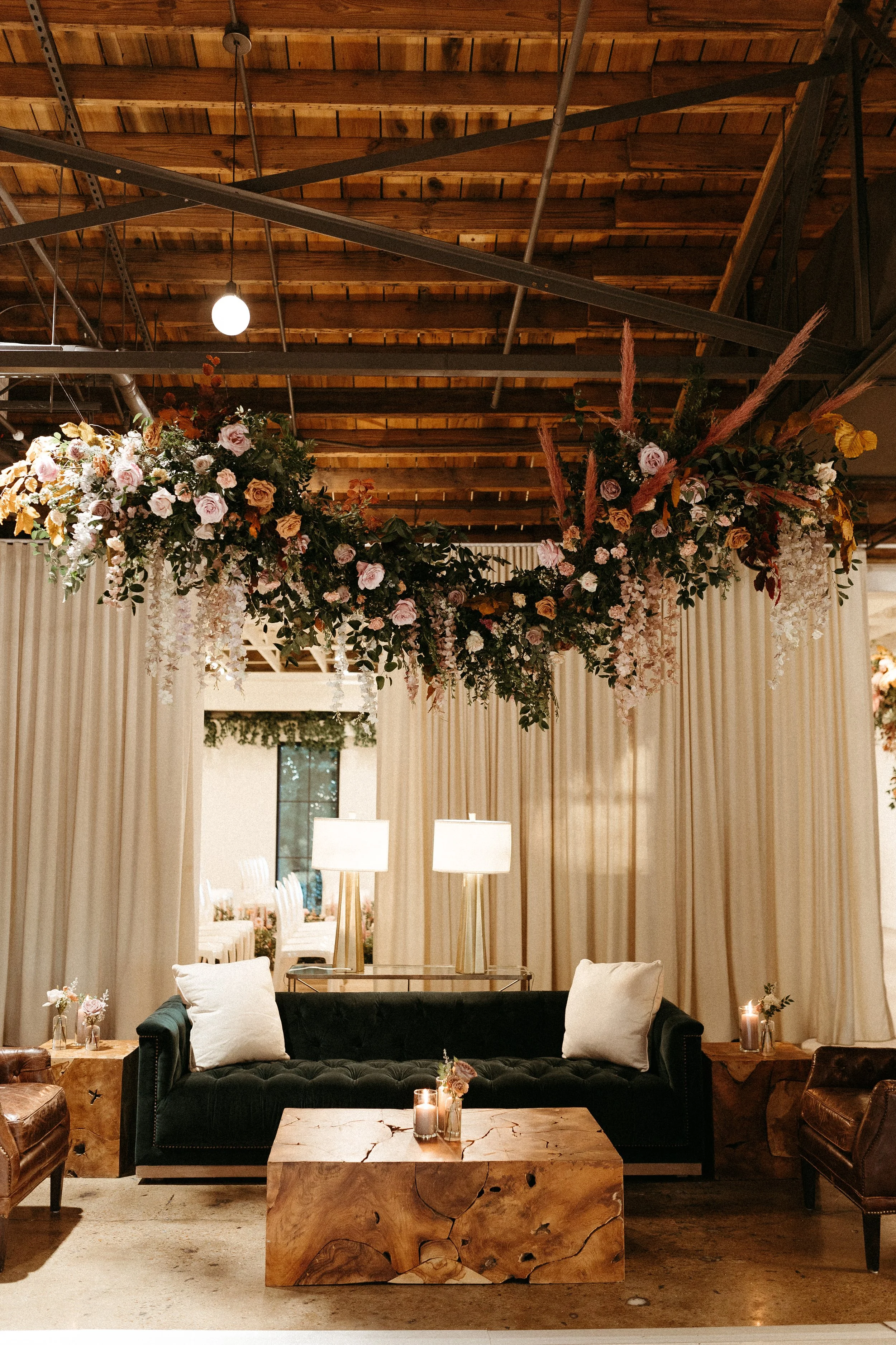 Stunning floral installations bring warmth to this Great Gatsby inspired wedding with florals of terra cotta, dusty pink, and burgundy hues. Petal heavy roses, wisteria, copper beech, and pink pampas grass accents. Designed by Rosemary and Finch in N