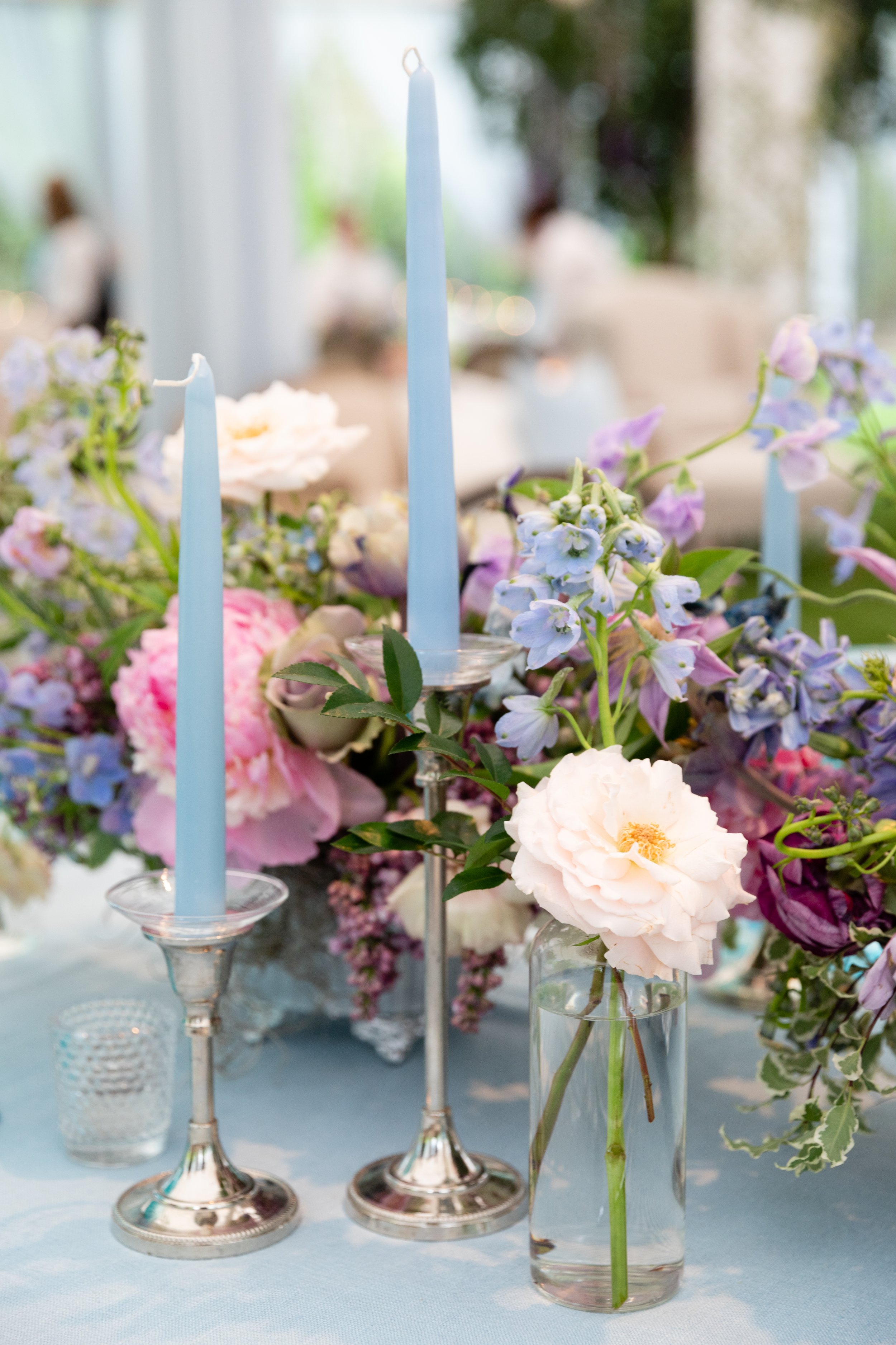 Growing, fresh floral centerpieces with blush garden roses, lilac, blue sweet peas, ranunculus, lavender delphinium, globe allium, clematis, and natural greenery for a tented Bridgerton inspired engagement party at a private home in Nashville, TN.
