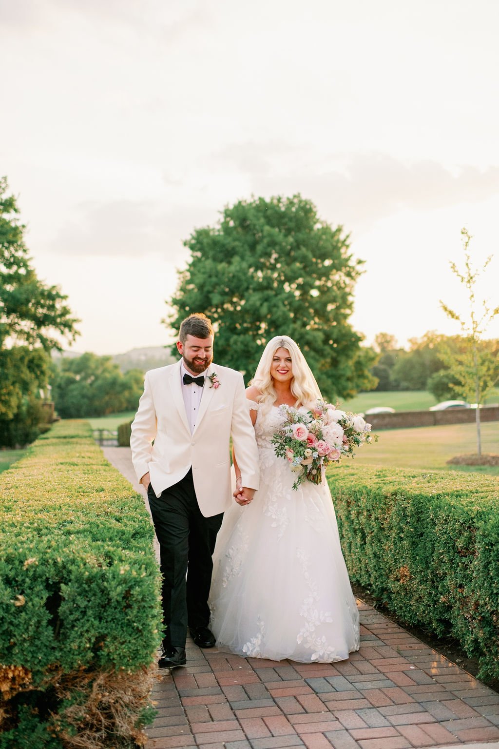 A lush bridal bouquet filled with hues of blush, pink, ivory, and hints of French blue. Garden roses, majolica spray roses, champagne roses, peonies, ranunculus, delphinium, and spirea make up this fairytale bouquet. Designed by Rosemary & Finch in N