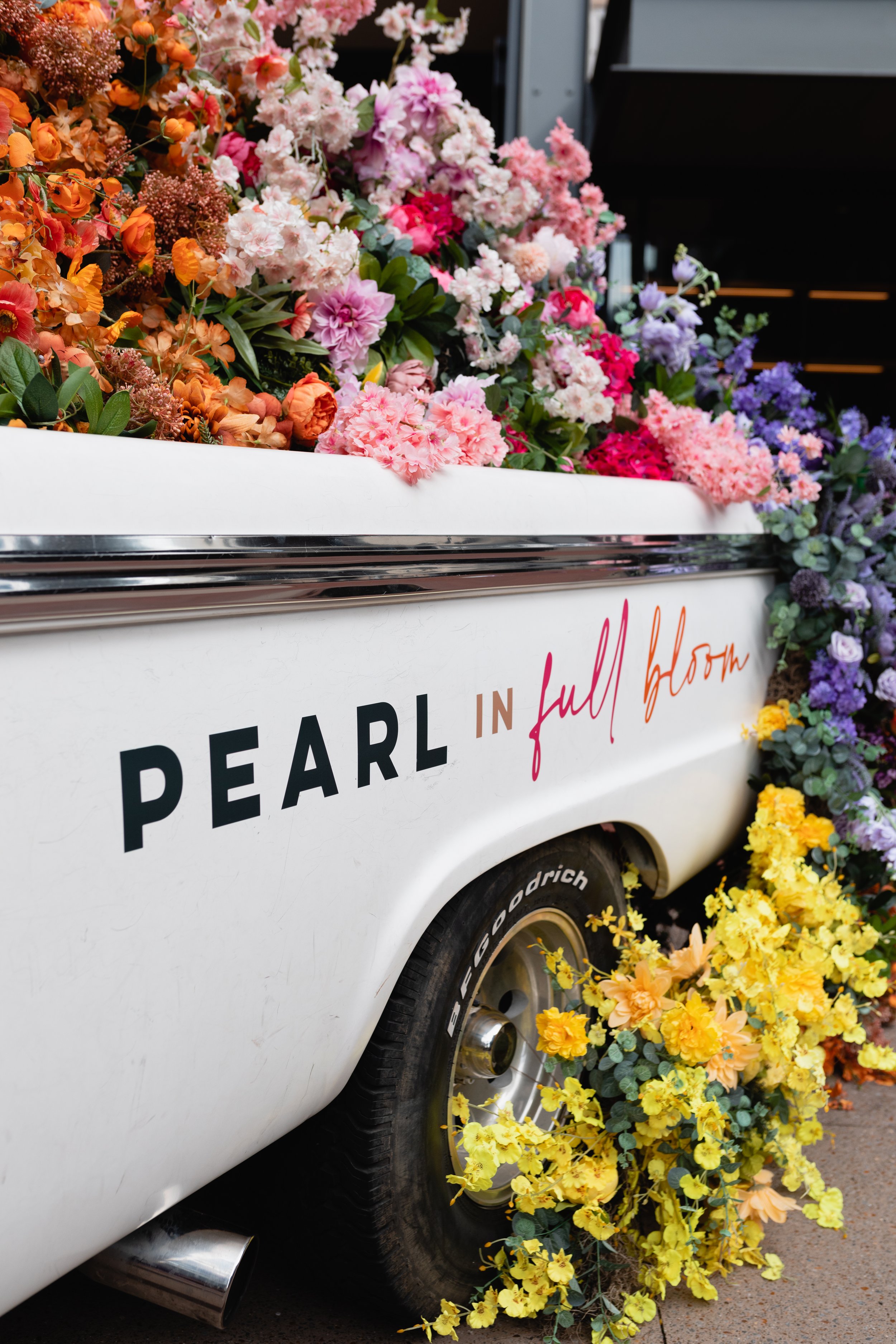 Cheerful pickup truck installation composed of silk floral hues in pink, magenta, lavender, coral, orange, yellow, and mixed greens bring to life this spring Fifth + Broadway event in Nashville, TN. Design by Rosemary and Finch.
