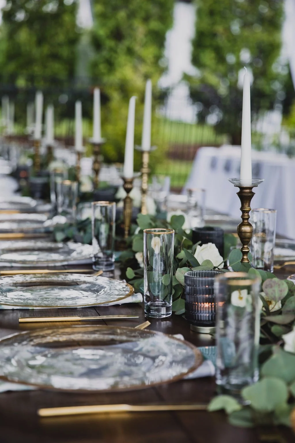 This backyard reception had a lush head table filled with garlands of eucalyptus, garden roses, ruscus, and spray roses. Designed by Rosemary and Finch in Nashville, TN.