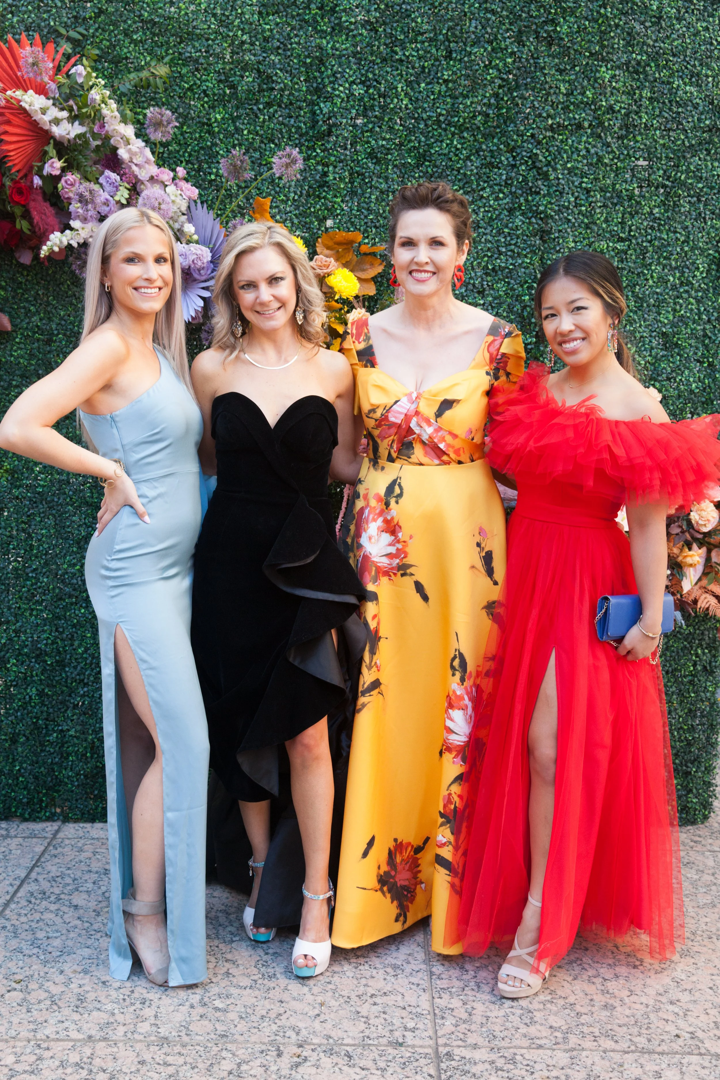 Modern colorful photo wall with rainbow hues of red, purple, yellow, blue, and orange. Comprised of roses, hydrangeas, tulips, snapdragons, dried palms, and anthurium. Designed by Rosemary and Finch in Nashville, TN.