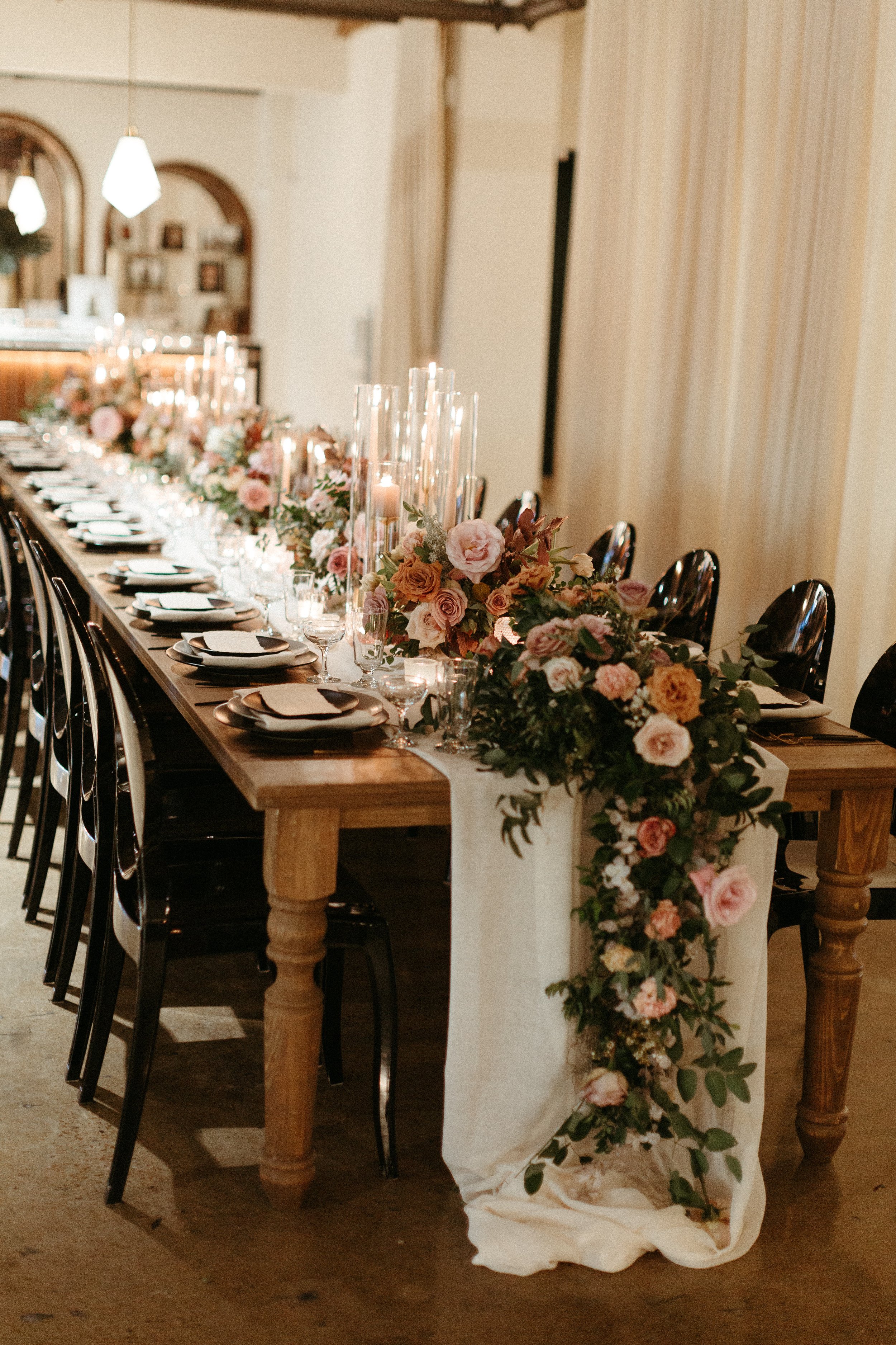 Beautiful floral cascades decorate the tables of this art deco wedding. Petal heavy roses, dried branches, and greenery bring floral hues of terra cotta, dusty pink, burgundy, and sage green. Designed by Rosemary and Finch in Nashville, TN.